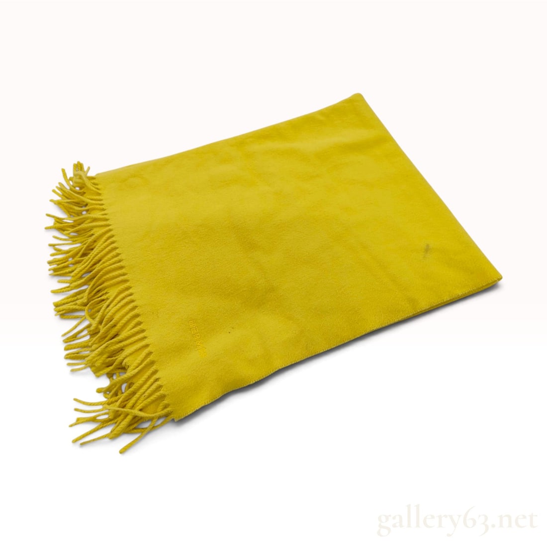 Hermes Yellow 100% Cashmere Fringed Scarf: This Hermes scarf is crafted from 100% cashmere in a vibrant solid yellow colorway. The rectangular wrap features twisted fringe edges at both ends and a textile with a visible fine diagonal twill wea