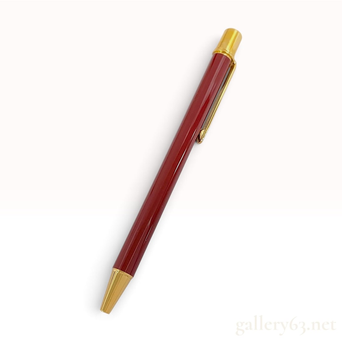 Must de Cartier Burgundy Lacquer and Gold Plated Ballpoint Pen with Box: This Must de Cartier ballpoint pen is crafted with a bordeaux or burgundy lacquer barrel and gold-plated metal hardware. The instrument features a slim profile and a push-button retractable mechanism.