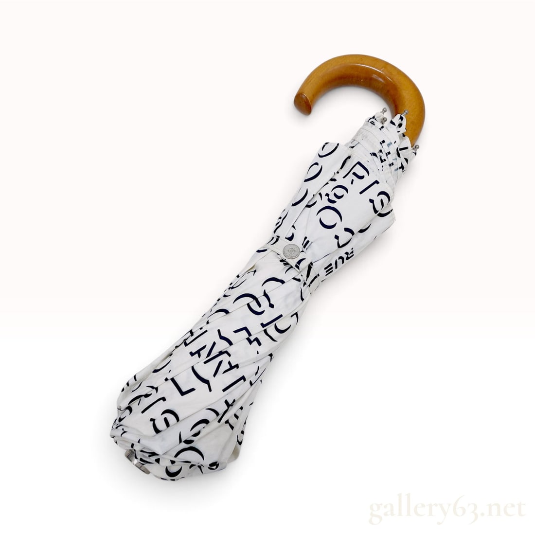 Vintage Chanel 31 Rue Cambon Print White Cotton Umbrella: This Chanel umbrella is crafted from a white cotton canopy featuring an all-over typographic print in black. The graphic design incorporates the words CHANEL, COCO, PARIS, and 31 RUE CAMBON alongside 