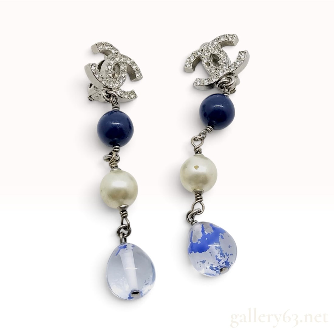 Vintage Chanel 11A Crystal Faux Pearl and Blue Glass CC Drop Earrings: These Chanel clip-on drop earrings are crafted from silver-finish base metal and date to the Autumn 2011 collection. The design features an interlocking CC logo top entirely set with pave colorless cr
