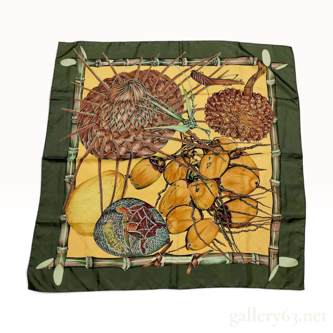 Vintage Hermes Jardin Creole (Creole Garden) Olive Green Silk Carre 90: This Hermes silk carre 90 in the Jardin Creole pattern was designed by Valerie Dawlat-Dumoulin. The design features a vibrant tropical still life including a woven straw hat, a cluster of yellow cocon