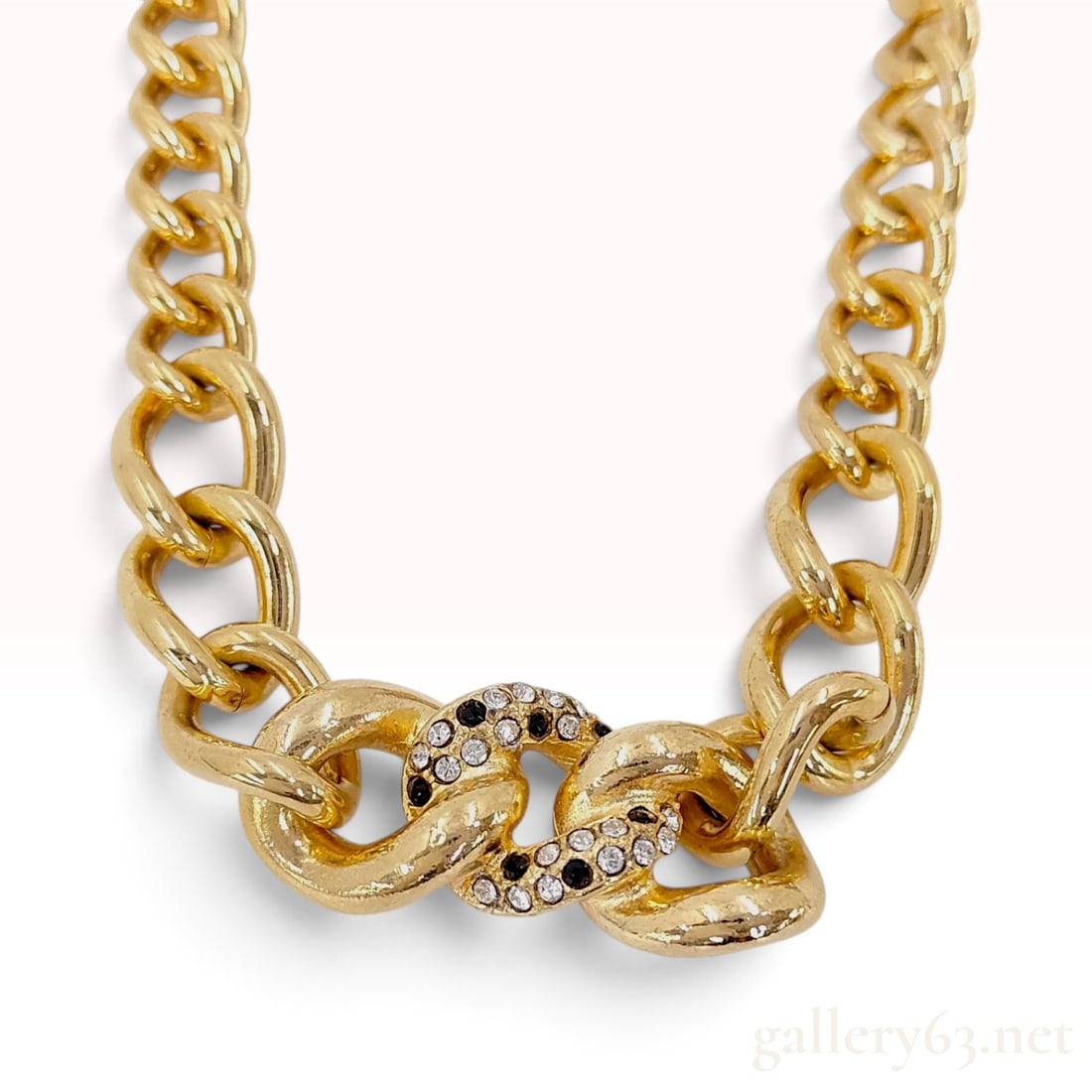 Vintage Christian Dior Chunky Gold Tone and Rhinestone Curb Link Necklace: This vintage Christian Dior necklace is crafted from gold-tone base metal with a heavy curb-style link construction. The bold statement design is centered by interlocking links pave-set with round-cut