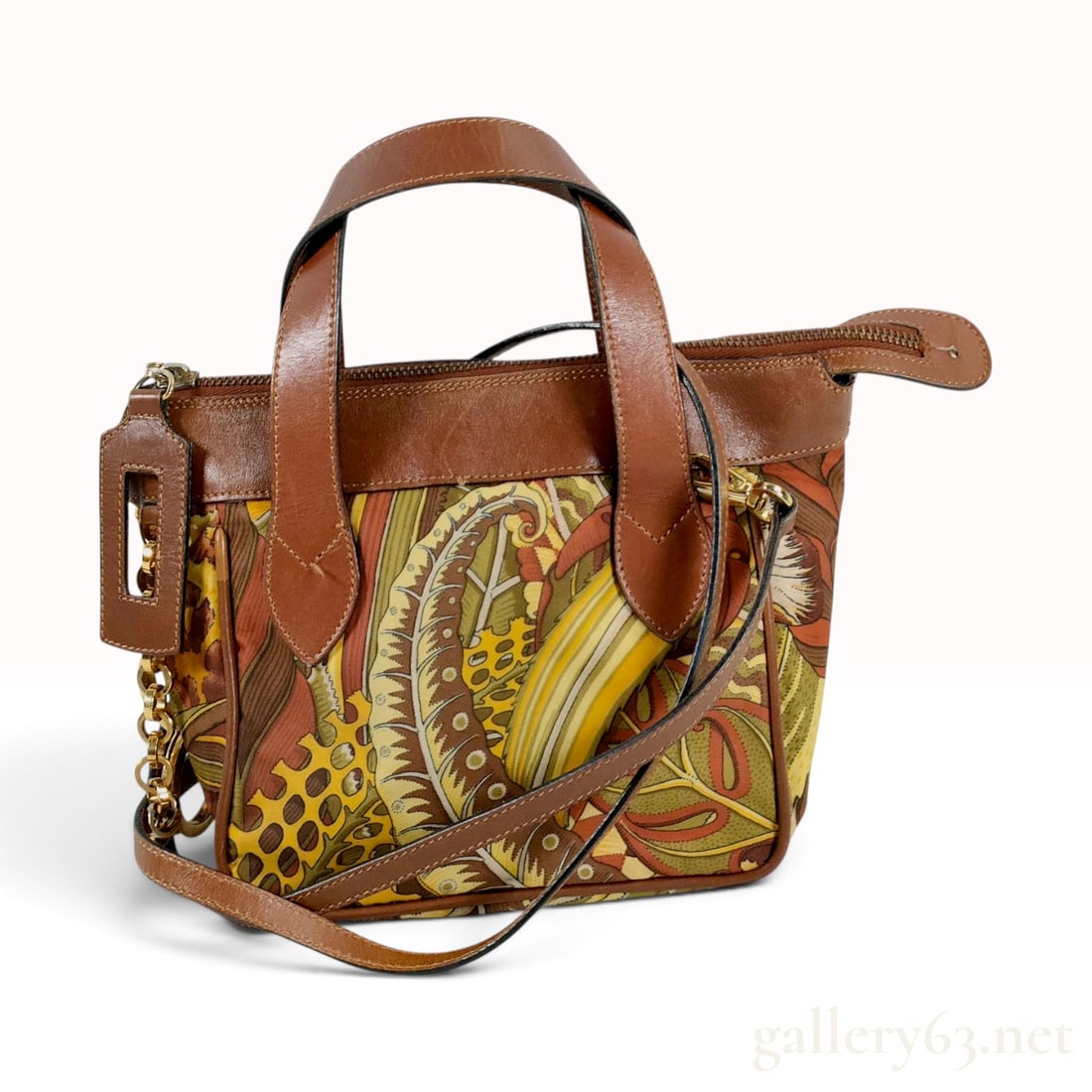 Salvatore Ferragamo Botanical Leaf Print and Brown Leather Mini Satchel Crossbody Bag: This Salvatore Ferragamo satchel is constructed from a botanical-patterned textile and smooth brown leather. The exterior features a print of various tropical leaves in green, yellow, orange, and tan,