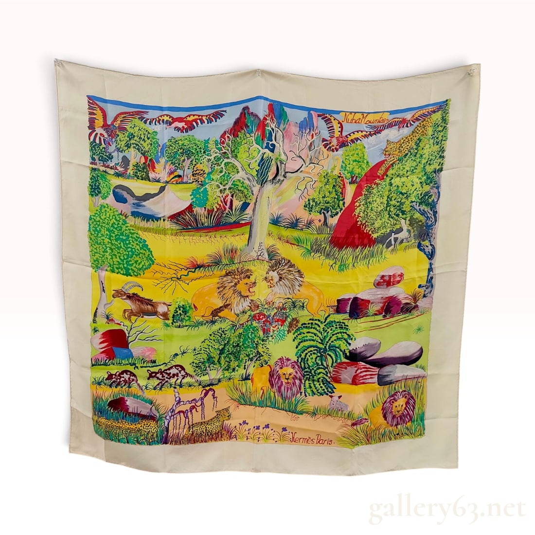Vintage Hermes Nuba Mountain Multicolor Silk Carre 90: This Hermes silk carre 90 features the Nuba Mountain pattern, designed by artist Sefedin Ibrahim Alamin. The composition presents a vibrant African landscape populated by lions, leopards, antelopes, a