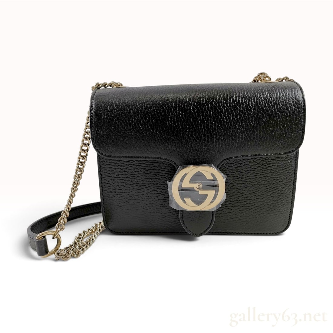 Gucci Interlocking G Black Pebbled Leather Small Crossbody Bag: This Gucci crossbody bag is crafted from black pebbled leather with a triple-gusset interior lined in beige canvas. The exterior design features a front flap secured by a snap button housed beneath a 
