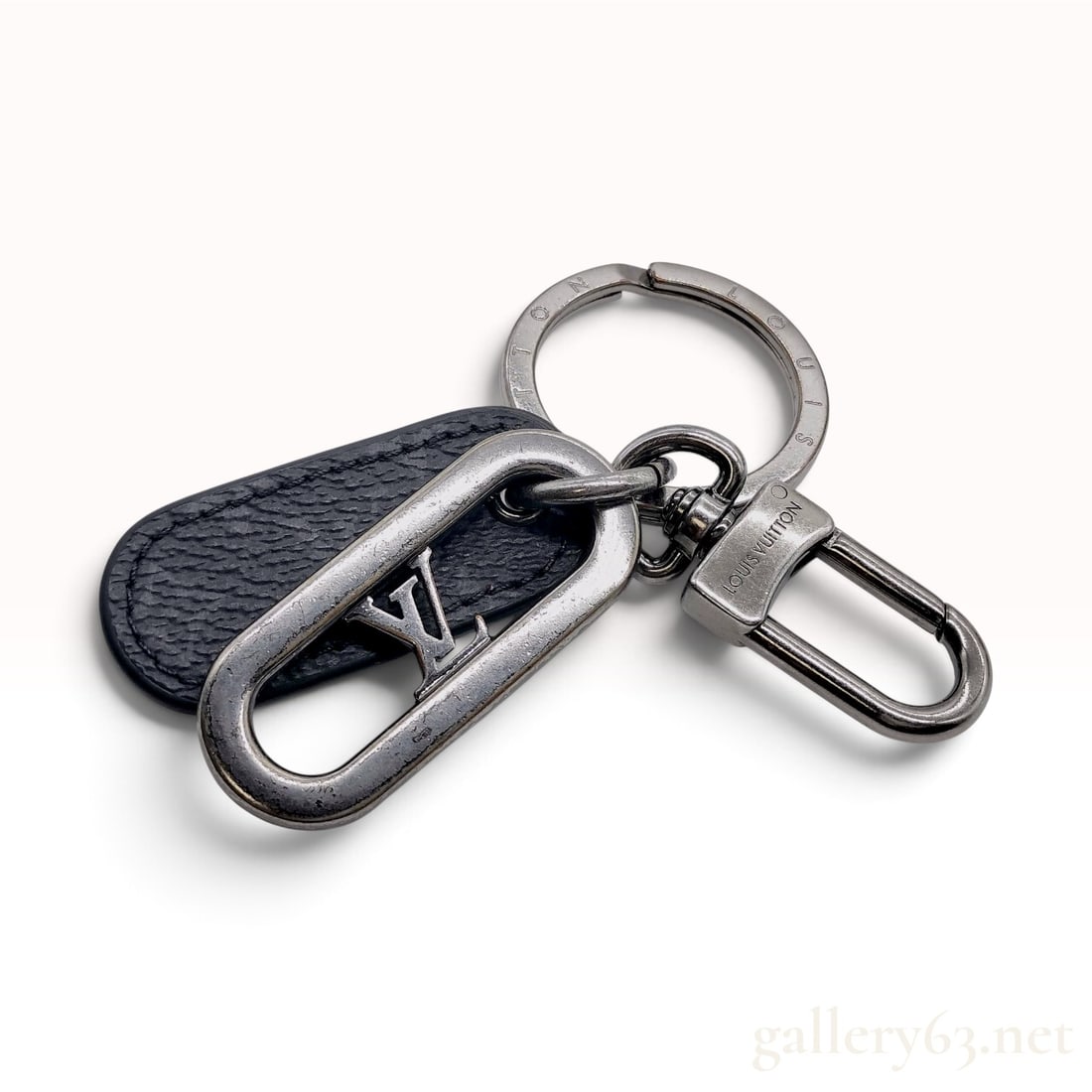 Louis Vuitton LV Link Key Holder in Monogram Eclipse with Box: This Louis Vuitton LV Link key holder and bag charm is constructed with a combination of Monogram Eclipse coated canvas and ruthenium-finished metal hardware. The accessory features a dark gray metal 