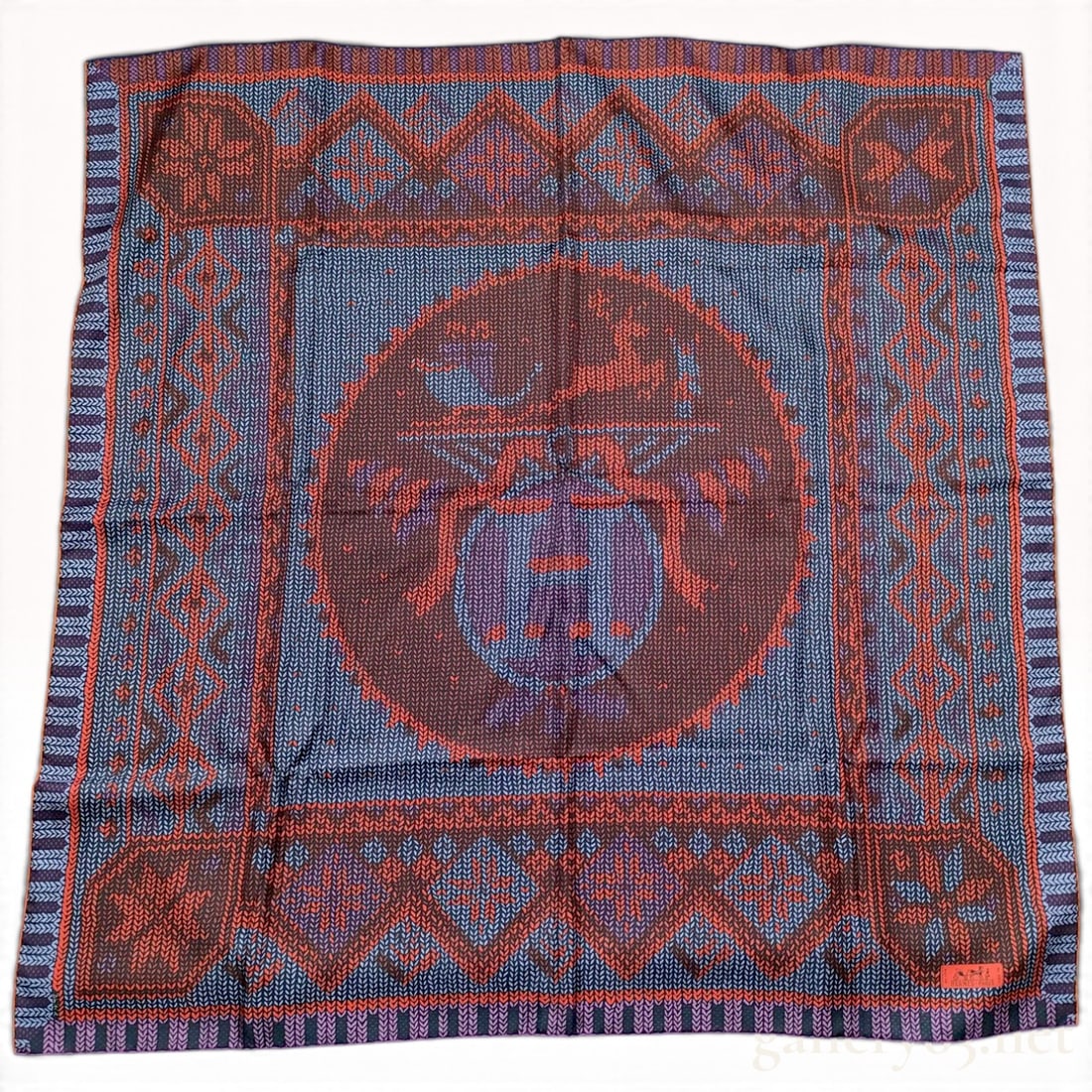 Hermes Au Coin Du Feu (At The Fireside) Red And Navy Silk Carre 90 With Box: This is a Hermes silk carre 90 in the Au Coin du Feu pattern designed by Henri d'Origny. The design features a trompe l'oeil graphic mimicking various knitwear textures and patterns, including Fair Is