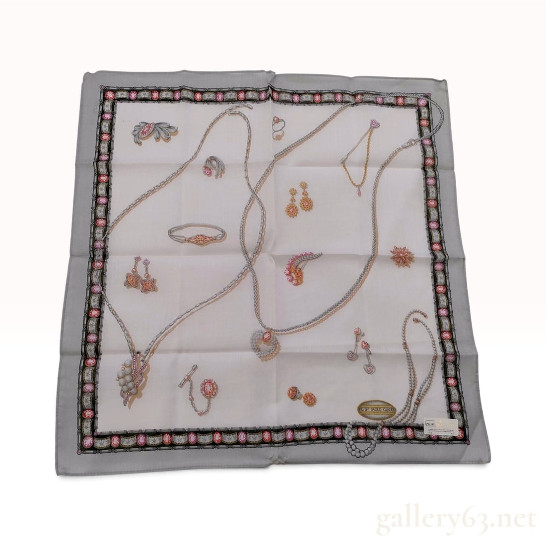 NWT Vintage Paolo Gucci Jewelry Motif Cotton Scarf 47 cm: This Paolo Gucci scarf is crafted from 100% cotton and features a jewelry-themed print. The central white field is printed with an assortment of necklaces, pearl strands, earrings, and brooches in gol