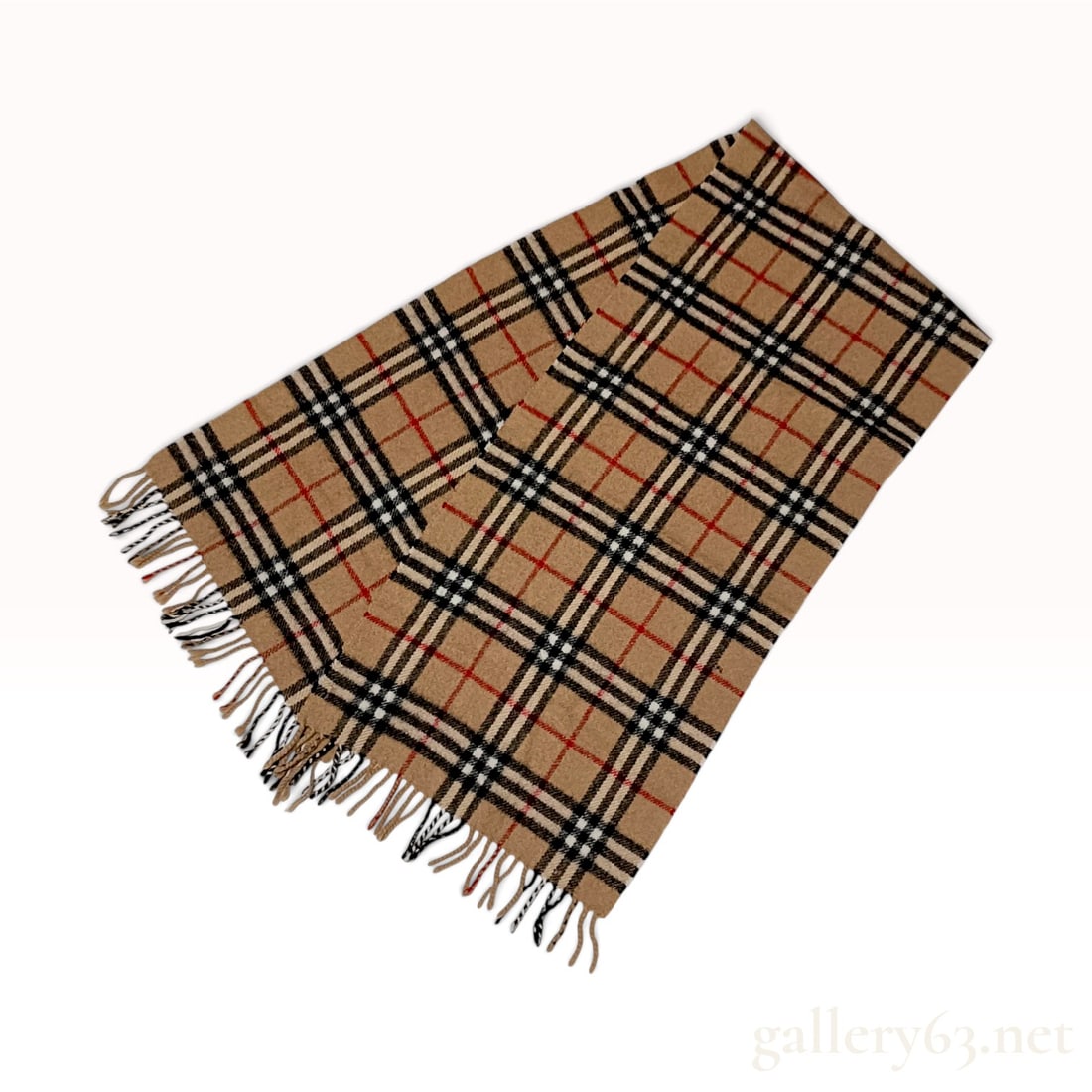 Vintage Burberrys Check Camel Lambswool Scarf: A vintage Burberrys scarf crafted from 100% lambswool in England. The design features the iconic house check pattern, characterized by thick black and white stripes intersected by thin red lines over 