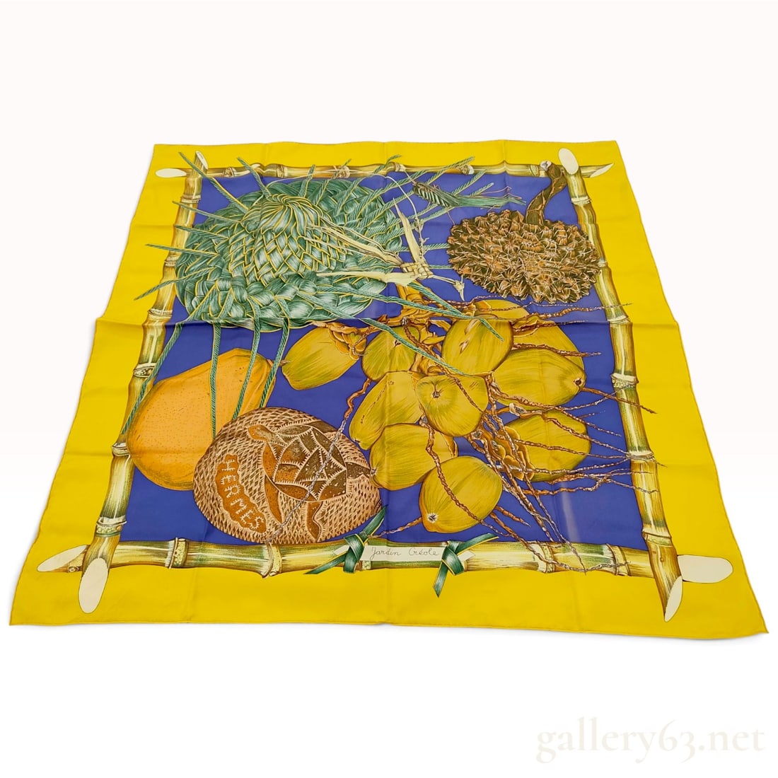 Hermes Jardin Creole (Creole Garden) Silk Carre 90: This Hermes silk carre 90 in the Jardin Creole pattern was designed by artist Valerie Dawlat-Dumoulin. The composition features a vibrant array of tropical flora and artifacts, including a large clust