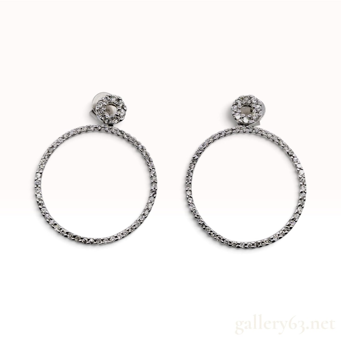 18 Karat White Gold 0.44ctw Natural Diamond Open Circle Drop Earrings: This pair of stud and open circle drop earrings is crafted from 18KWG. Each earring features a circular stud top pave-set with round brilliant-cut natural diamonds. Suspended from the stud is a larger