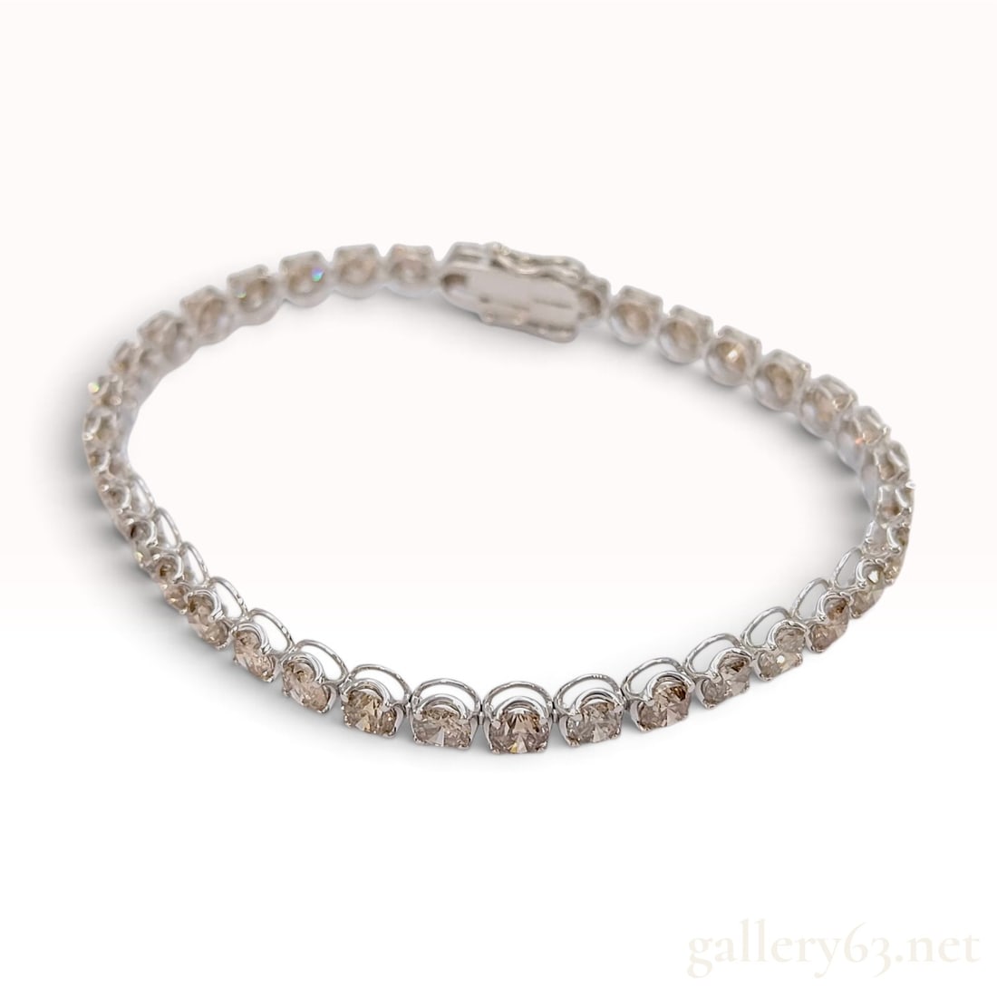 18K White Gold 10.00ct Natural Diamond Tennis Bracelet: This 18 karat white gold tennis bracelet is set with a continuous line of round brilliant cut natural diamonds. Each gemstone is individually secured in a four-prong basket setting, arranged in an art