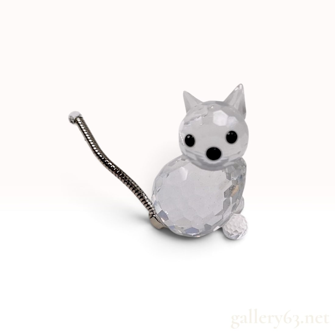 Swarovski 010011 Crystal Cat Figurine with Box: A Swarovski crystal cat figurine featuring a faceted clear lead crystal body and head. The head is detailed with two pointed clear crystal ears and three black crystal cabochons serving as the eyes an