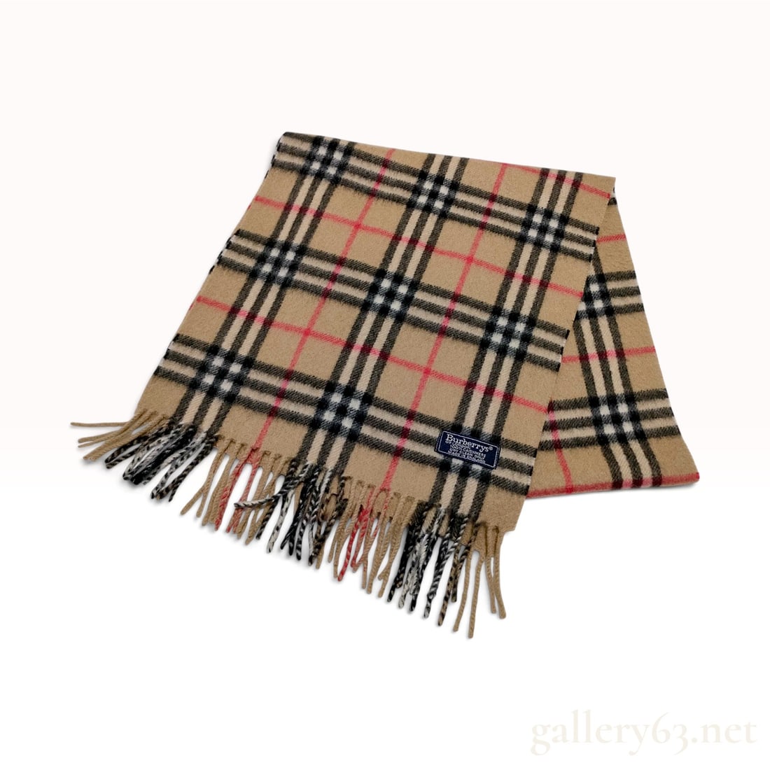 Vintage Burberrys Classic House Check Tan Cashmere Scarf: This Burberrys scarf is crafted from 100% cashmere in the brand's signature house check pattern. The woven design features a tan ground with intersecting black and white stripes and a red overcheck, a