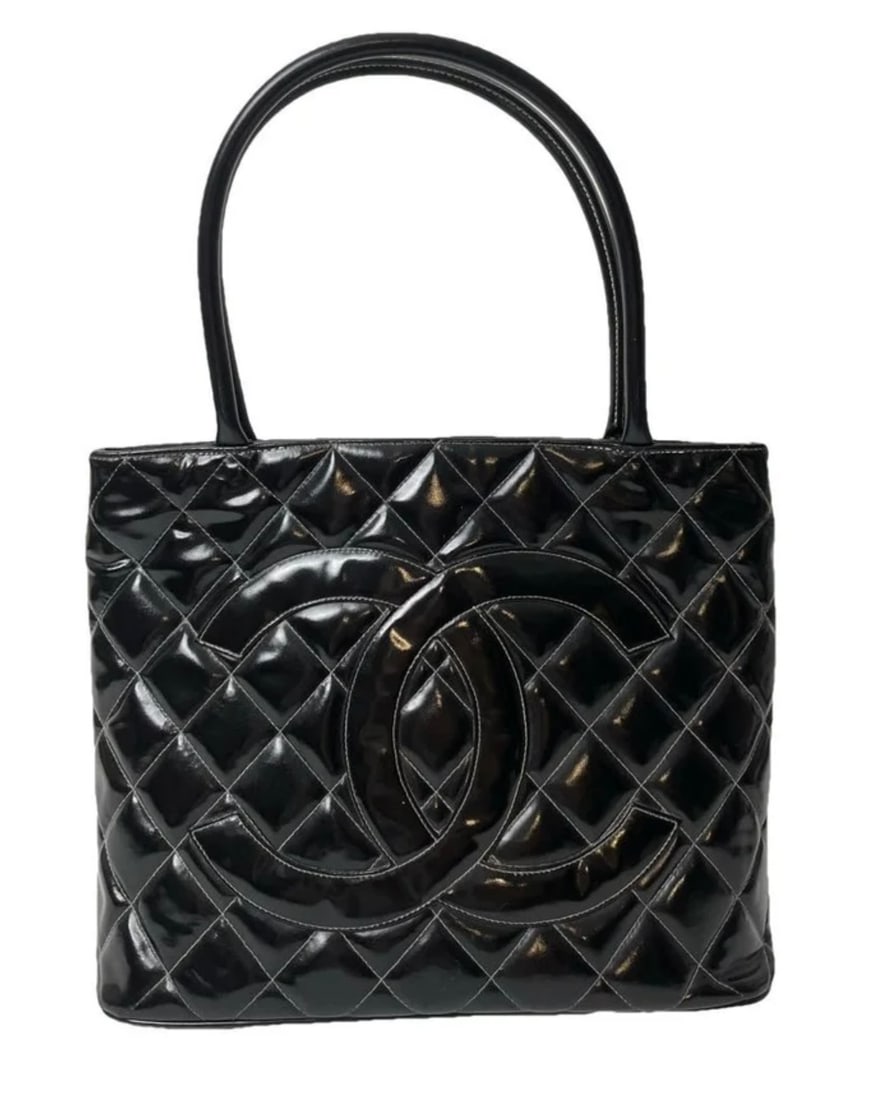 CHANEL MEDAILLON TOTE, BLACK PATENT / GOLD: Description: Chanel Medaillon tote in black quilted patent leather with gold-tone hardware. Diamond-quilted body with the oversized CC stitched to the front panel, rolled patent top handles with contr