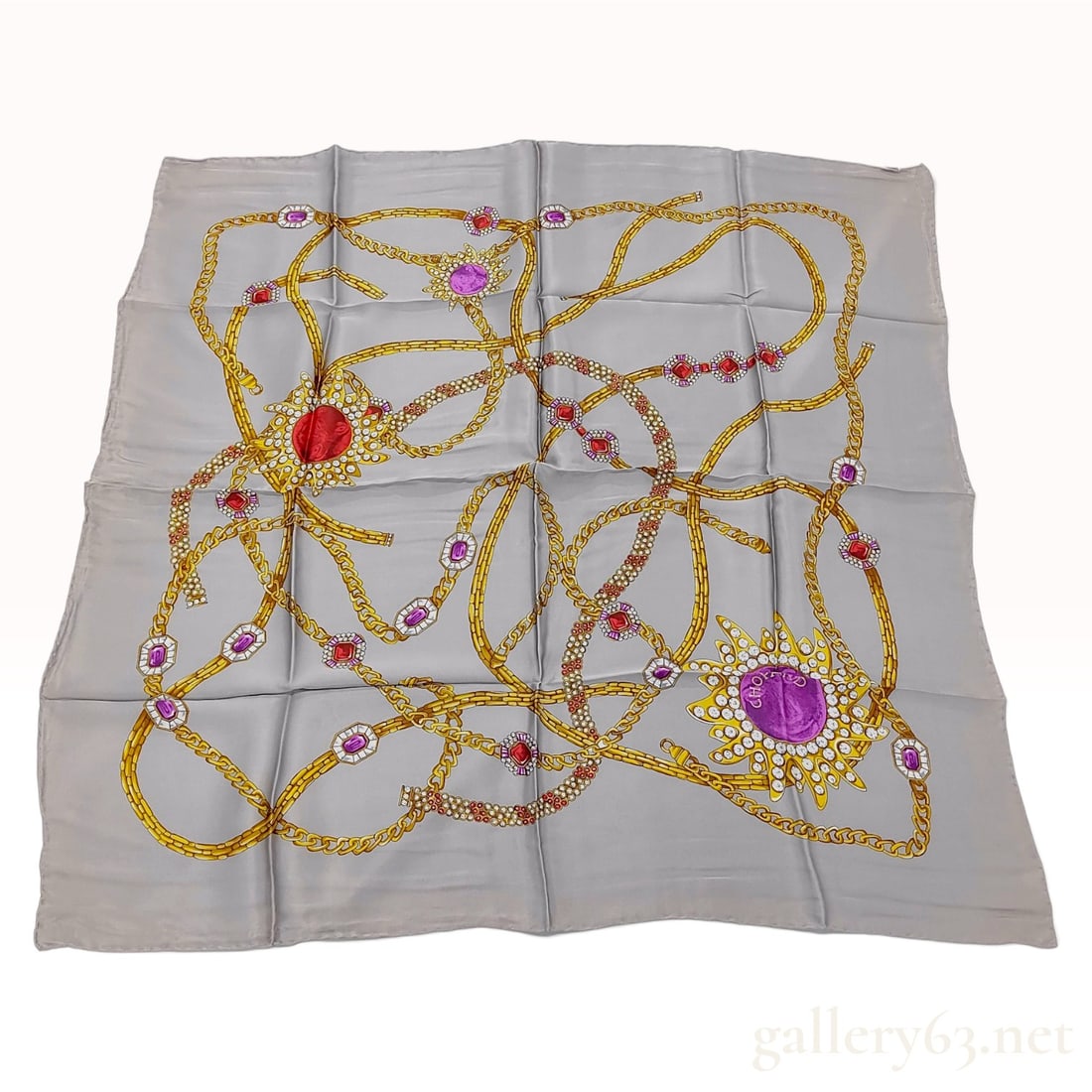Vintage Chopard Jewelry Motif Silver-Gray Silk Scarf 90cm: This Chopard silk carre 90 is crafted from 100% Italian silk and features an elaborate jewelry motif set against a solid silver-gray ground. The design displays an array of intertwined yellow gold cha