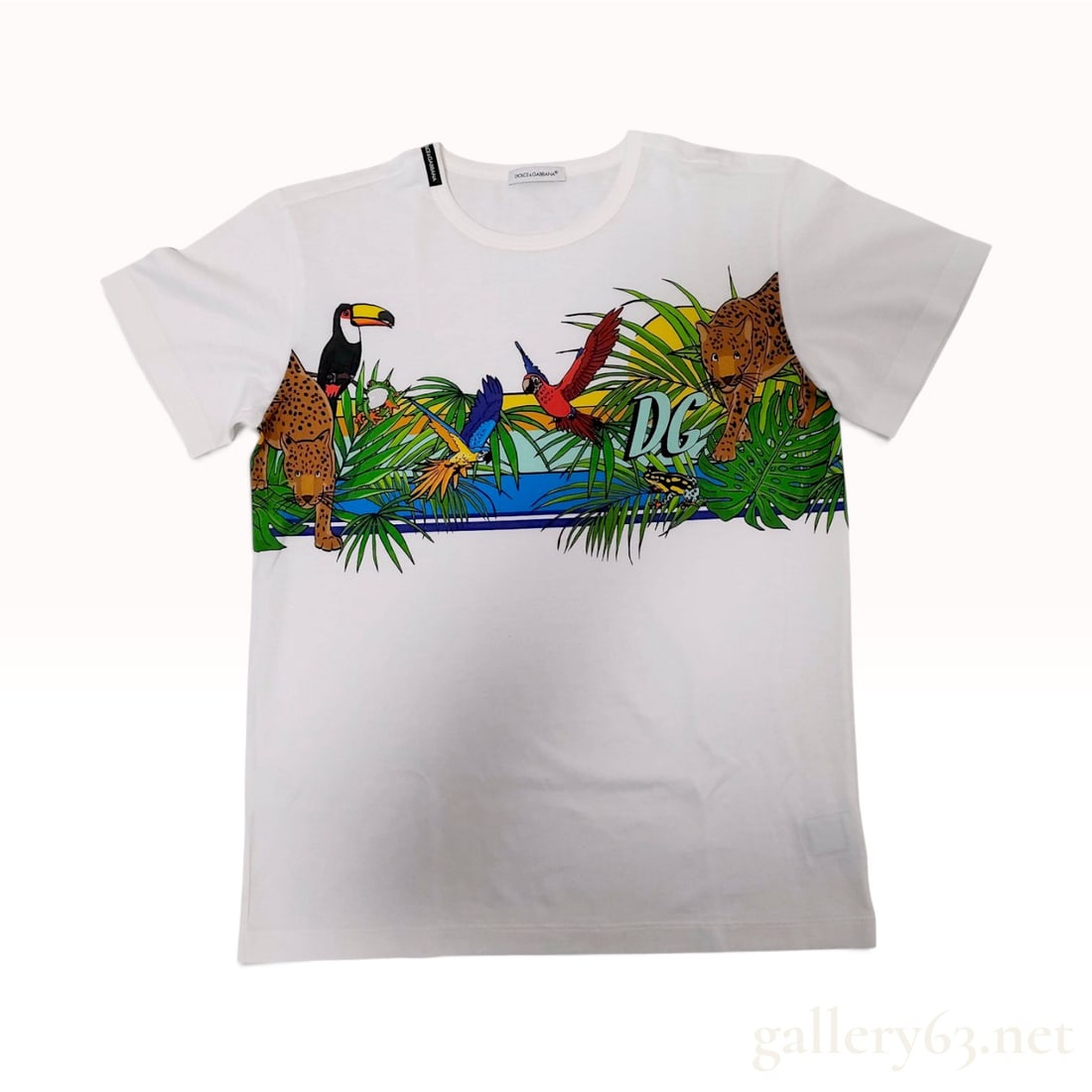 Dolce & Gabbana Jungle Theme White Cotton T-Shirt: This Dolce & Gabbana short-sleeved t-shirt is crafted from a white cotton jersey. The front features a vibrant screen-printed tropical jungle motif depicting two leopards, a toucan, and parrots among 