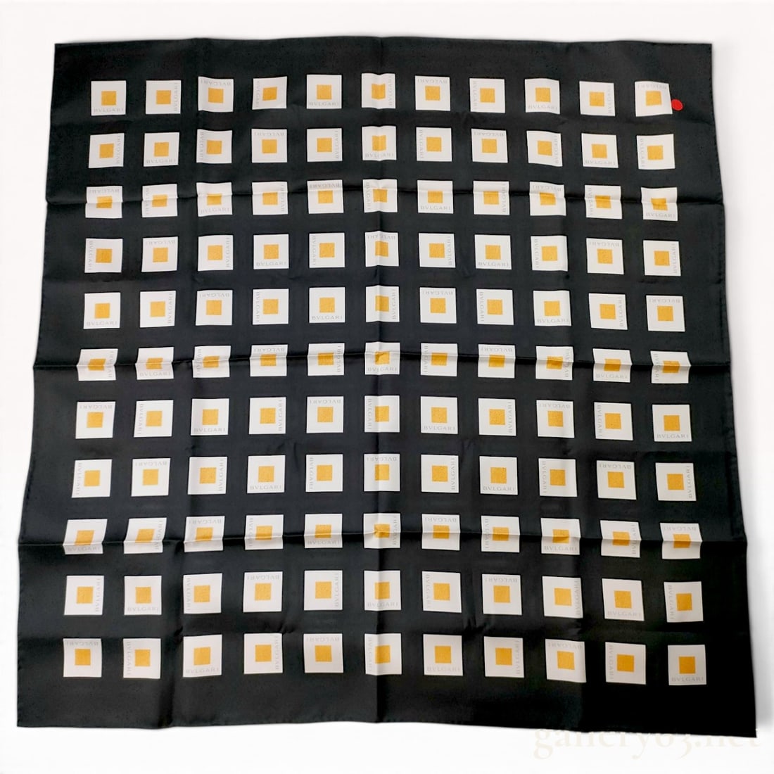 Vintage BVLGARI Geometric Motif Black and Gold Silk Scarf 90 cm: This BVLGARI silk scarf 90 cm is crafted from 100% silk with hand-rolled and hand-stitched edges. The design features a geometric grid of white squares on a black ground, each containing a textured go