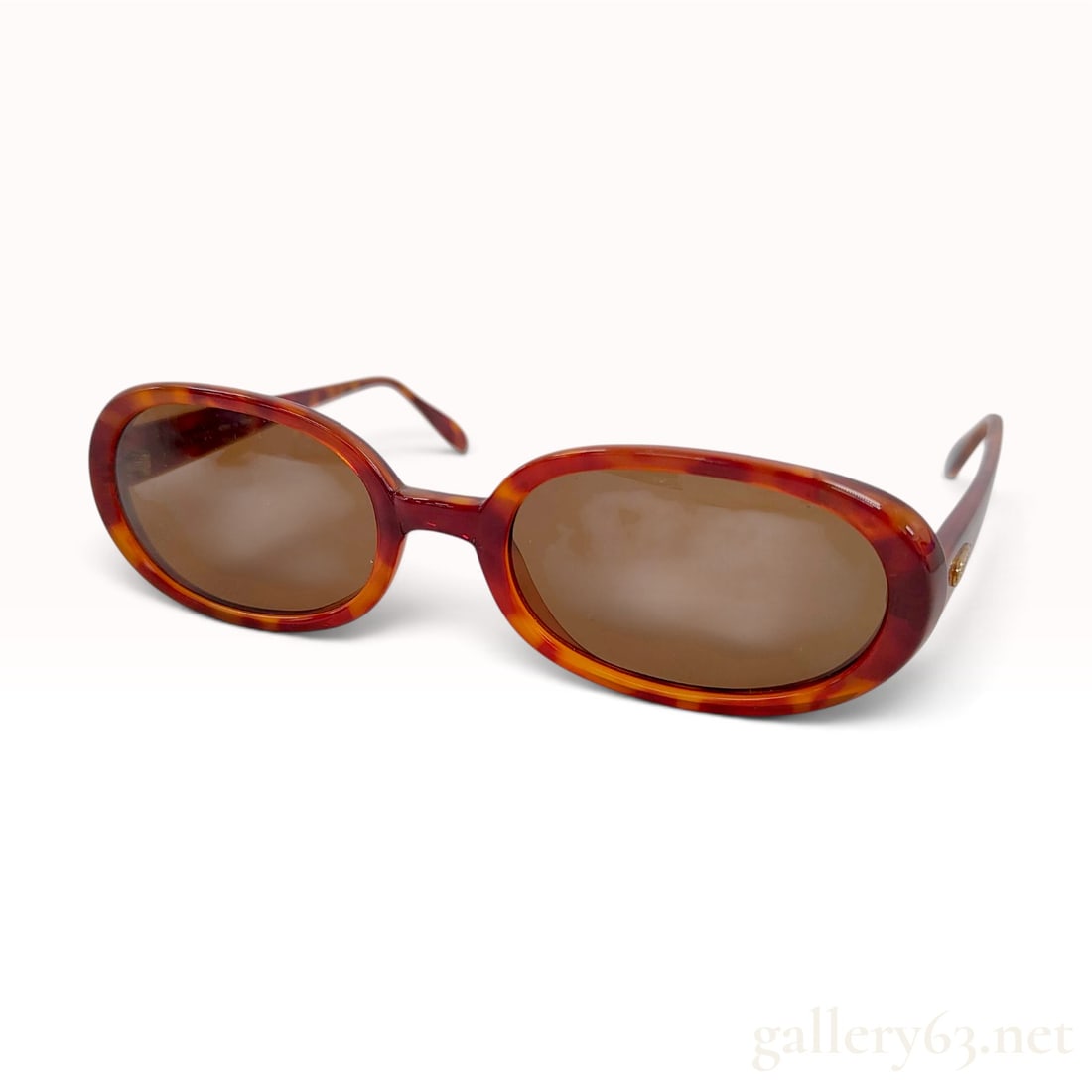 Guess GU 795 SUN Tortoiseshell Acetate Oval Sunglasses with Case: These Guess oval sunglasses are crafted from high-gloss acetate in a classic amber and dark brown tortoiseshell pattern. The frames feature a rounded oval silhouette with integrated nose pads and a re