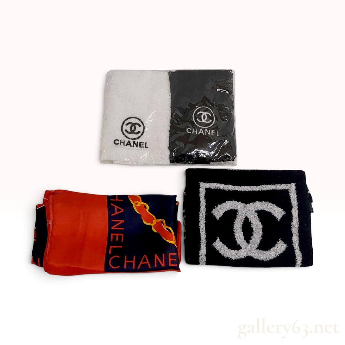 Chanel Logo Chain Motif Scarf and Terry Cloth Towels with Original Packaging: This is an assortment of Chanel textile accessories comprising a scarf and multiple towels. The square scarf is crafted from a red, navy blue, and white satin-weave textile featuring a graphic chain m