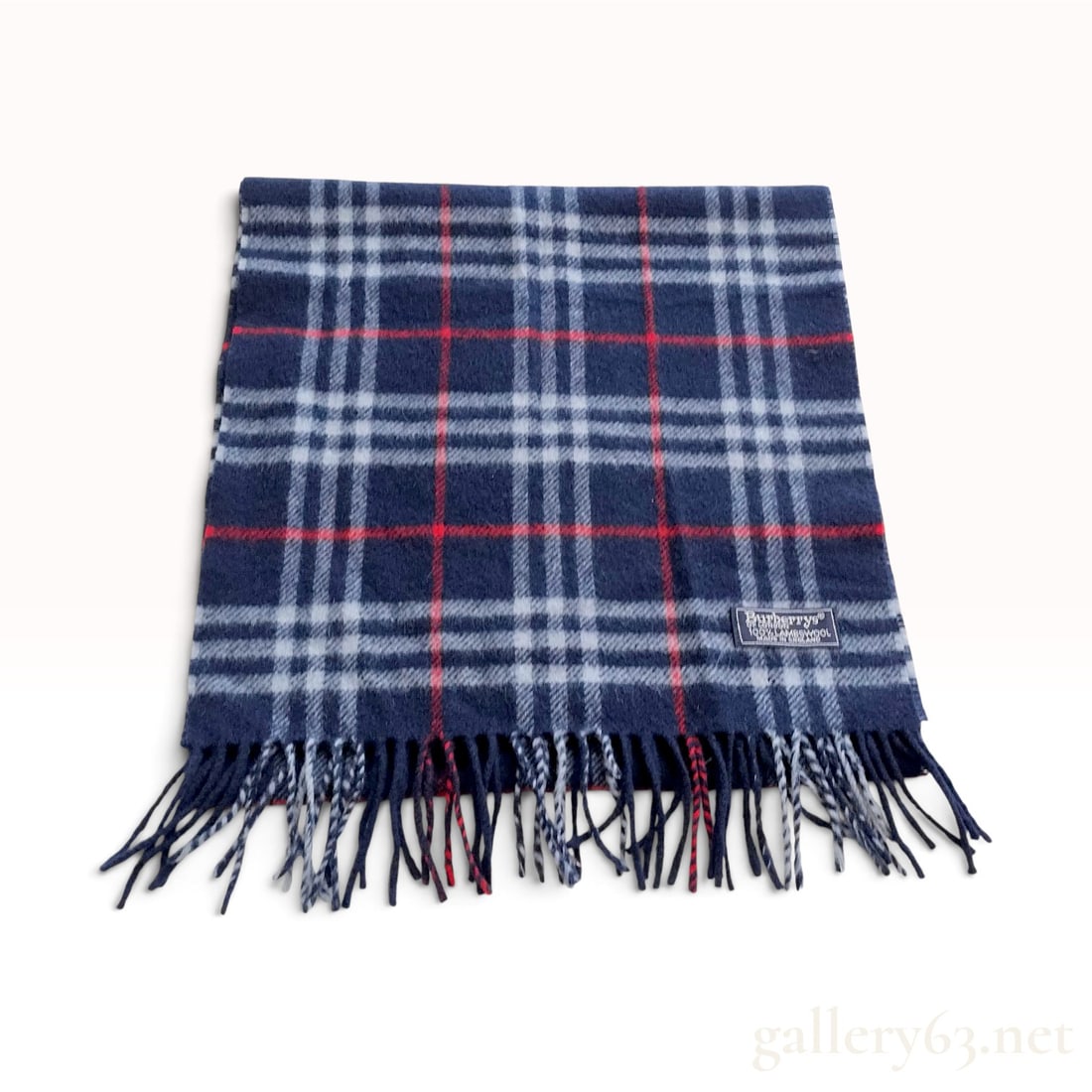 Vintage Burberrys Navy Check 100% Lambswool Scarf: A vintage Burberrys neck scarf crafted from 100% lambswool in a classic navy blue check pattern. The woven textile features a dark navy ground intersected by a grid of white and red stripes. Both ends