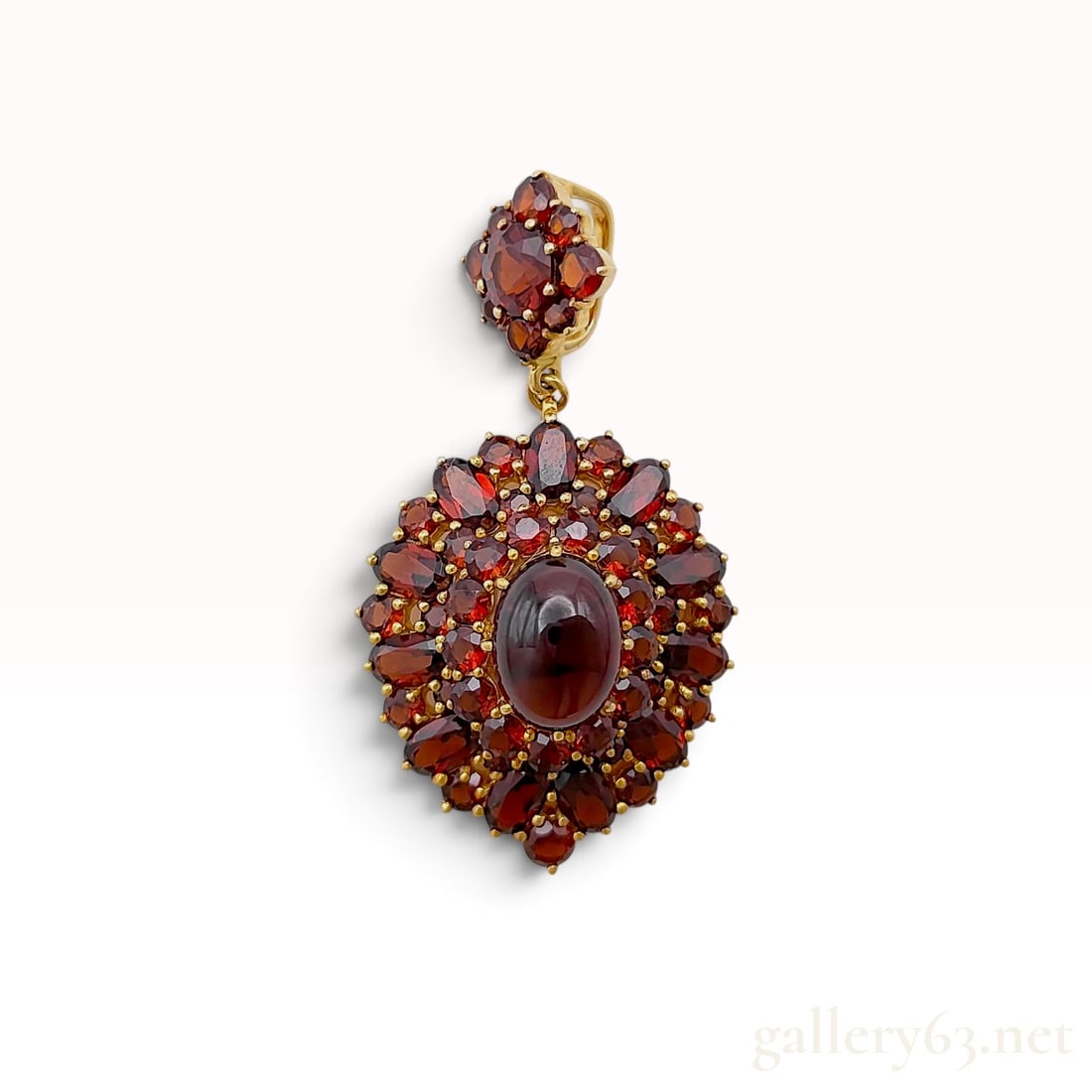 A Vintage 18 Karat Yellow Gold and 9.17ct Garnet Tiered Cluster Pendant: This vintage tiered cluster pendant is crafted from 18 karat yellow gold and set with natural garnets in a tiered beehive arrangement. The design centers on a large oval cabochon garnet in a multi-pro