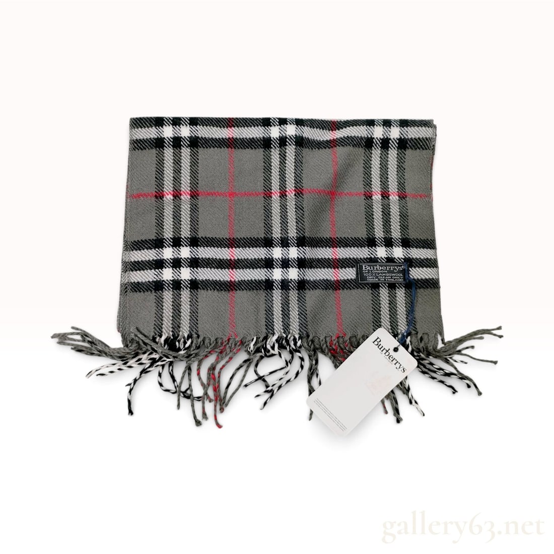 Vintage Burberrys Nova Check Gray Lambswool Scarf NWT: This Burberrys scarf is crafted from 100% lambswool. The design features the signature Nova Check pattern in a gray colorway, consisting of a medium gray ground with intersecting black, white, and red