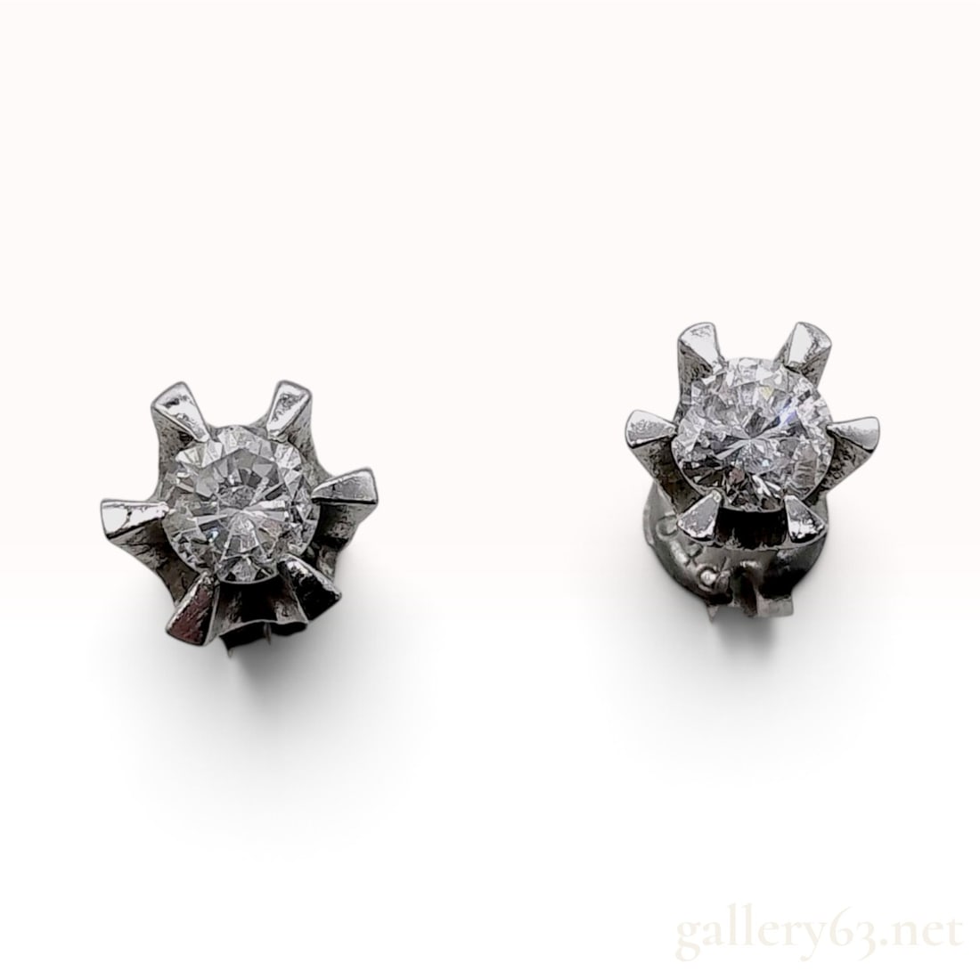 Platinum and 0.60ctw Natural Diamond Buttercup Stud Earrings: This matched pair of platinum stud earrings features two round brilliant cut natural diamonds. Each diamond is held in a secure six-prong crown or buttercup-style setting. The diamonds have a combined