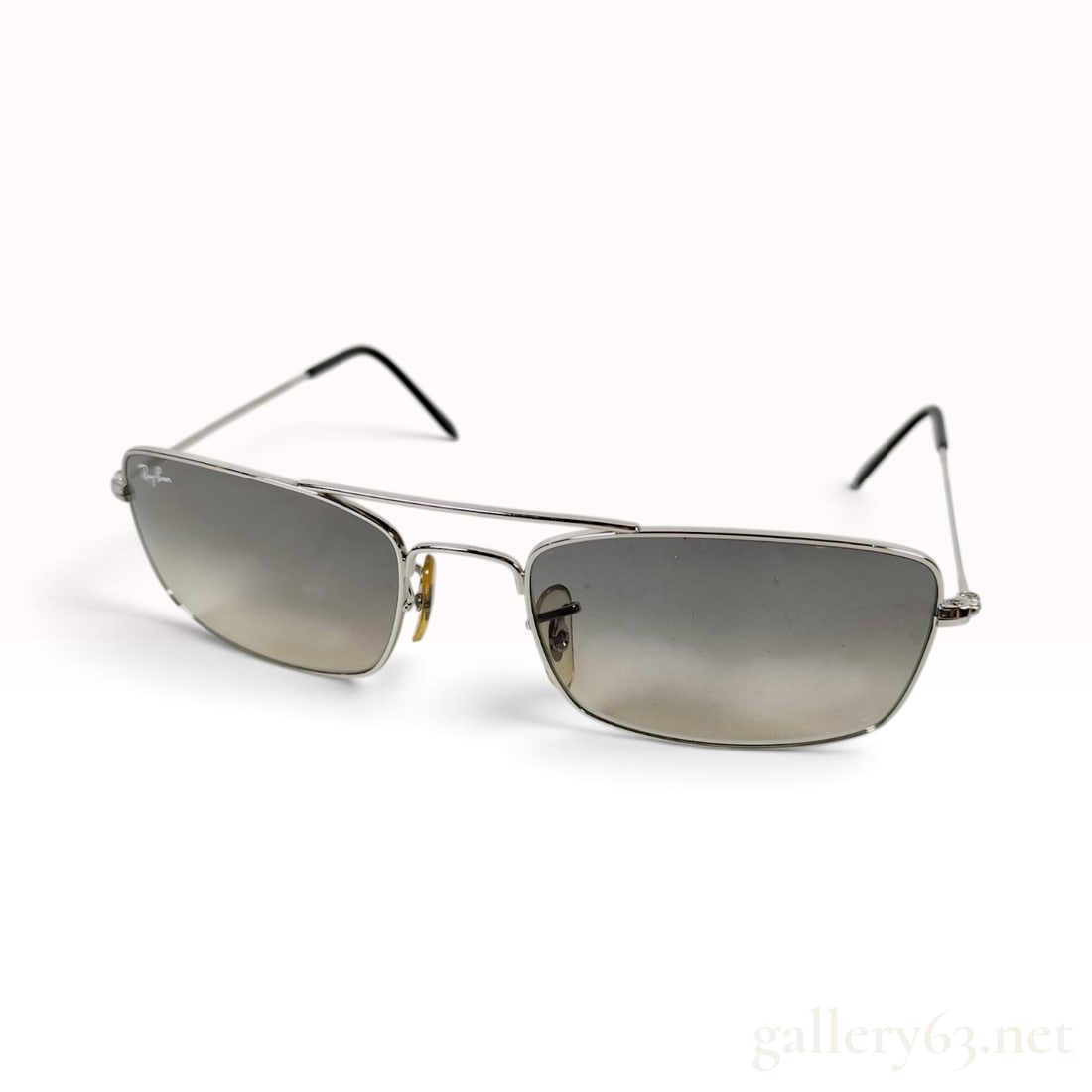 Ray-Ban RB 3309 Silver Metal Sunglasses: This pair of Ray-Ban RB 3309 sunglasses is constructed with a silver metal rectangular wrap-style frame and a double bridge. The gradient lenses transition from a dark gray-brown top to a light yellow