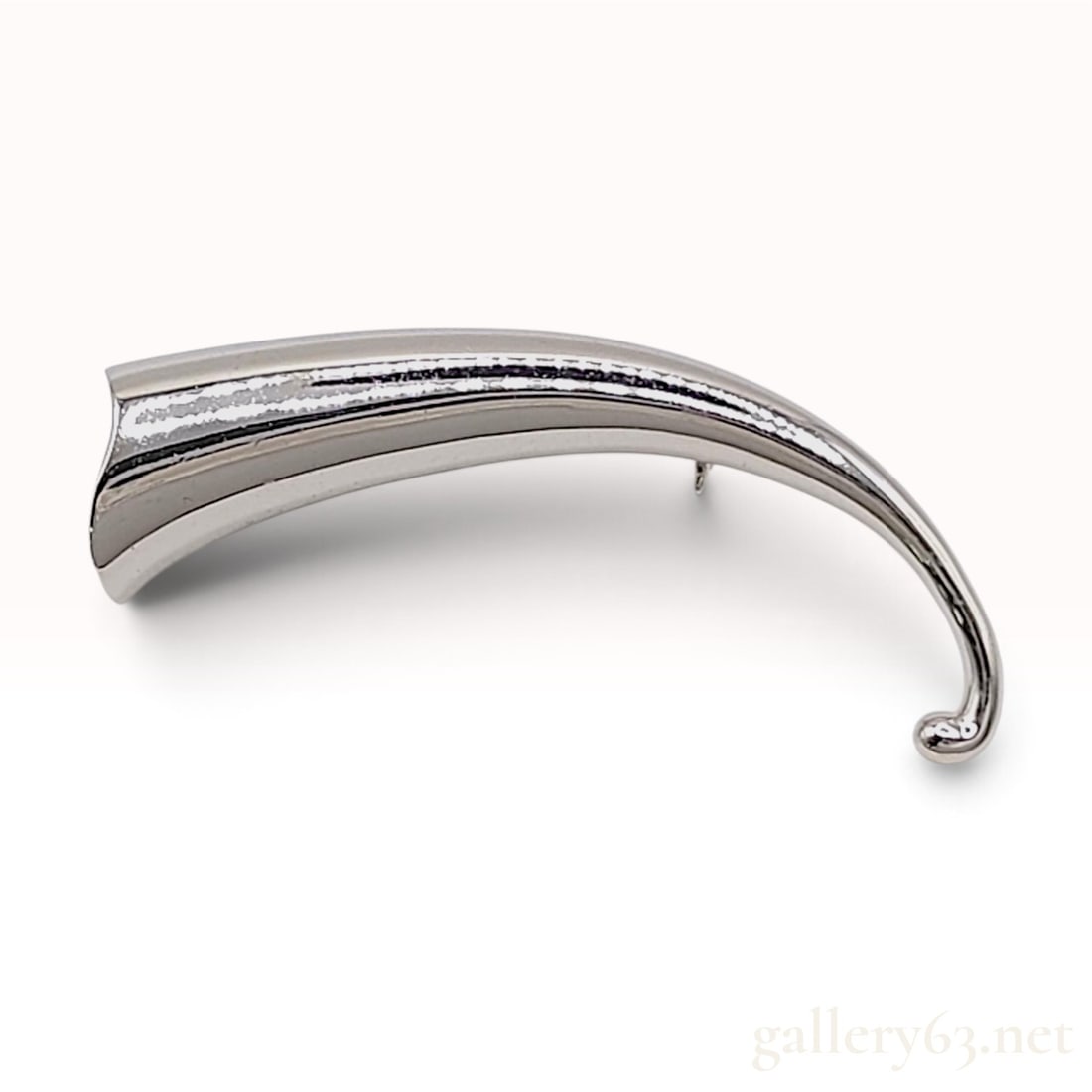 Sterling Silver Modernist Horn Brooch: This sterling silver brooch is crafted in a minimalist tapering horn or cornucopia form. The polished body features a curved, hollow construction that terminates in a small ball finial at one end and 