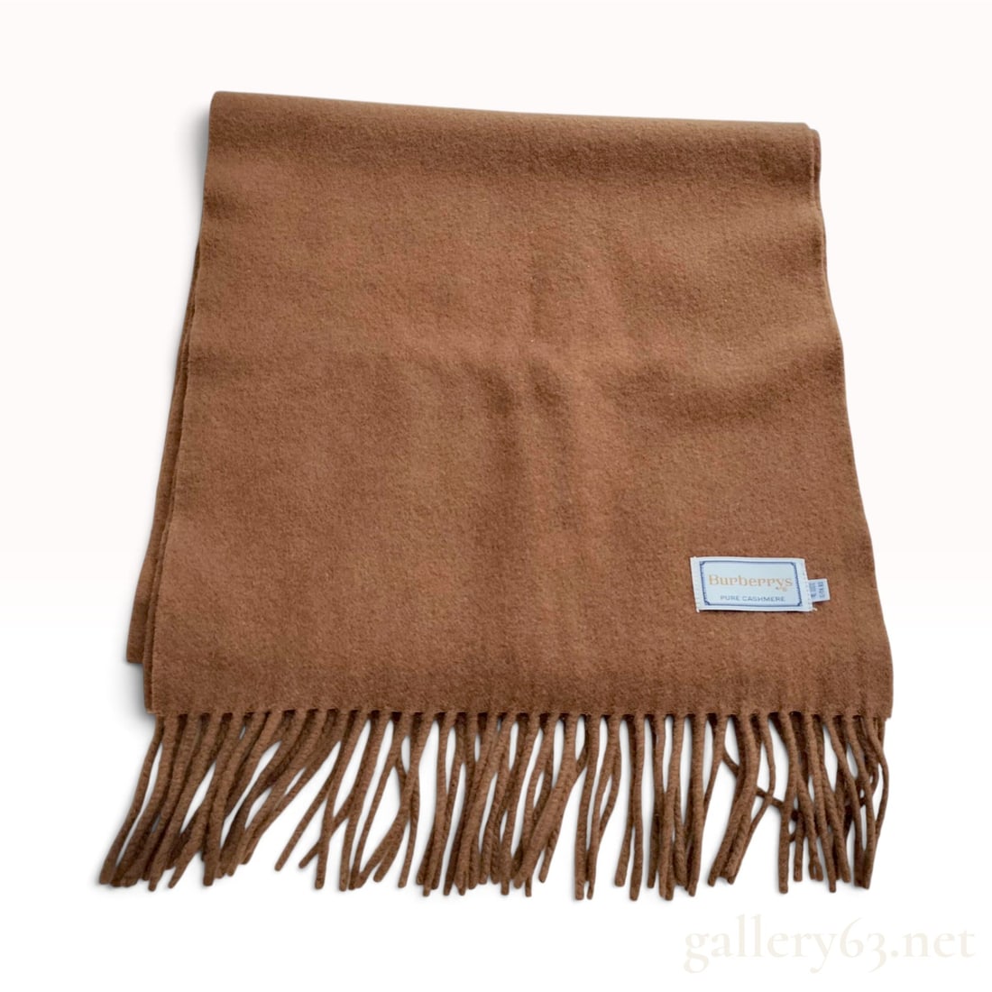 A Vintage Burberrys Camel Brown Pure Cashmere Scarf 30cm: This vintage Burberrys scarf is crafted from pure cashmere in a solid camel brown colorway. The piece features a soft, brushed surface texture and is finished with twisted fringe at both ends. One cor