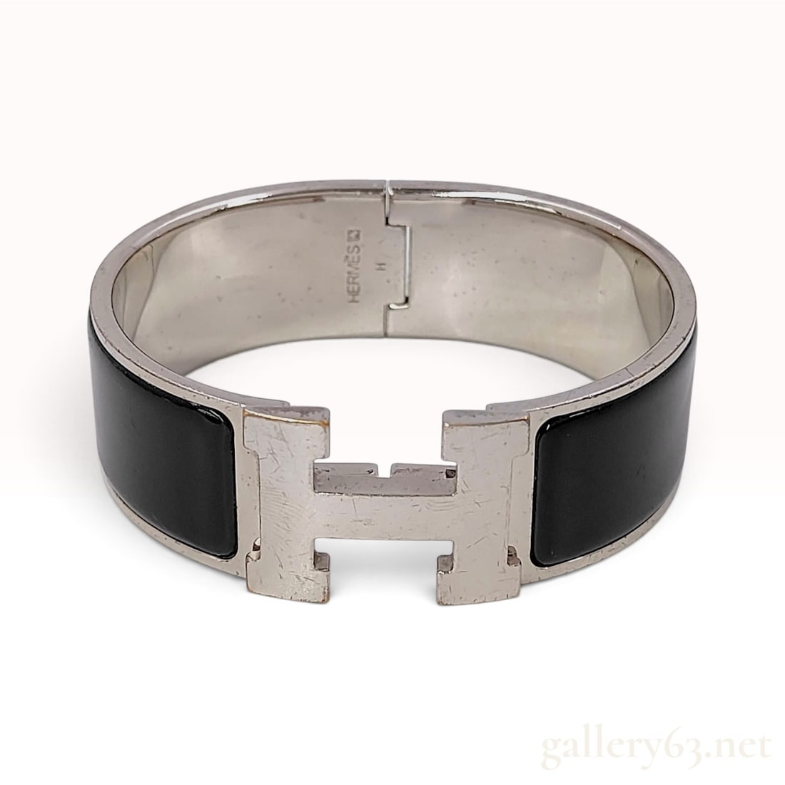 Herm?¨s Clic Clac H Black Enamel Bangle Bracelet 16 cm: This Herm?¨s Clic Clac H bangle is crafted from polished metal featuring dual black enamel inlays. The jewelry item is designed with a hinged band and a signature rotating clasp mechanism shaped as a