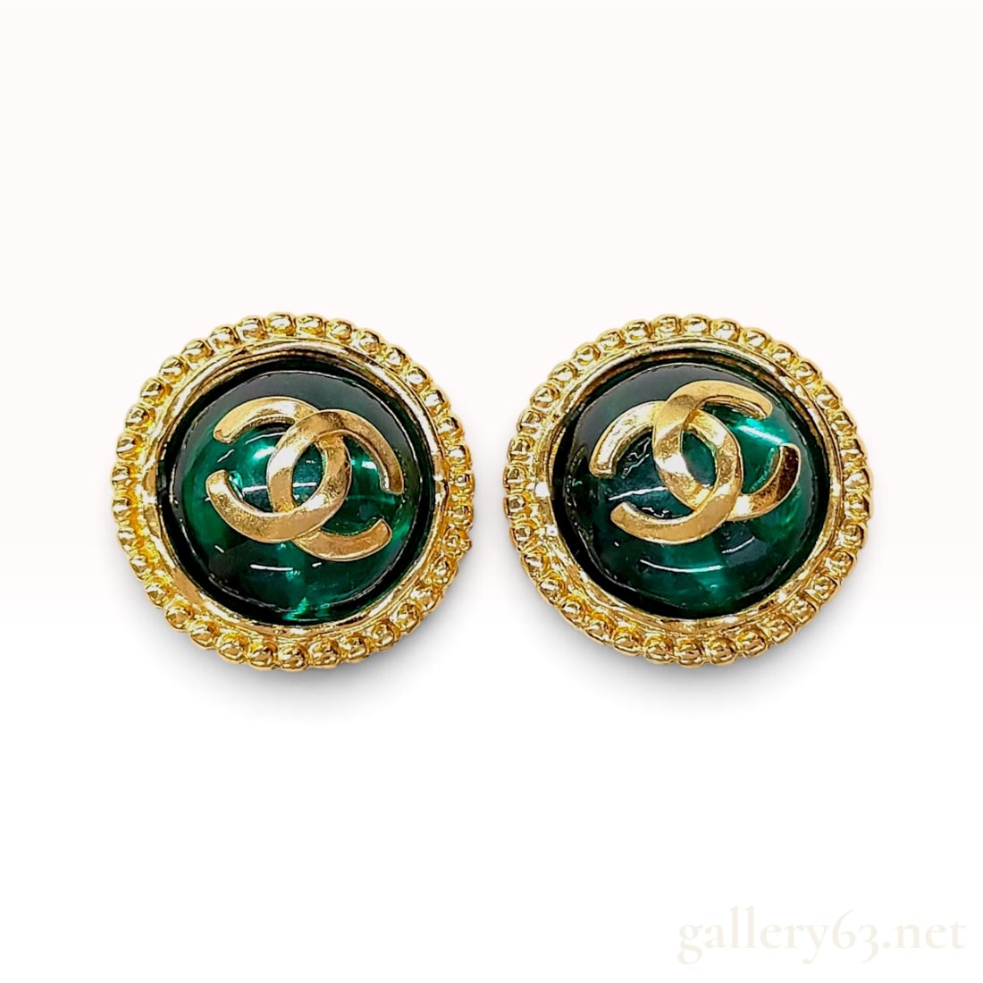 A Pair of Vintage Chanel 94A Green Gripoix Glass and Gold-Toned CC Logo Button Earrings: This pair of Chanel 94A button earrings is crafted from gold-toned base metal and emerald green Gripoix poured glass cabochons. Each earring features a raised gold-toned interlocking CC logo set atop 