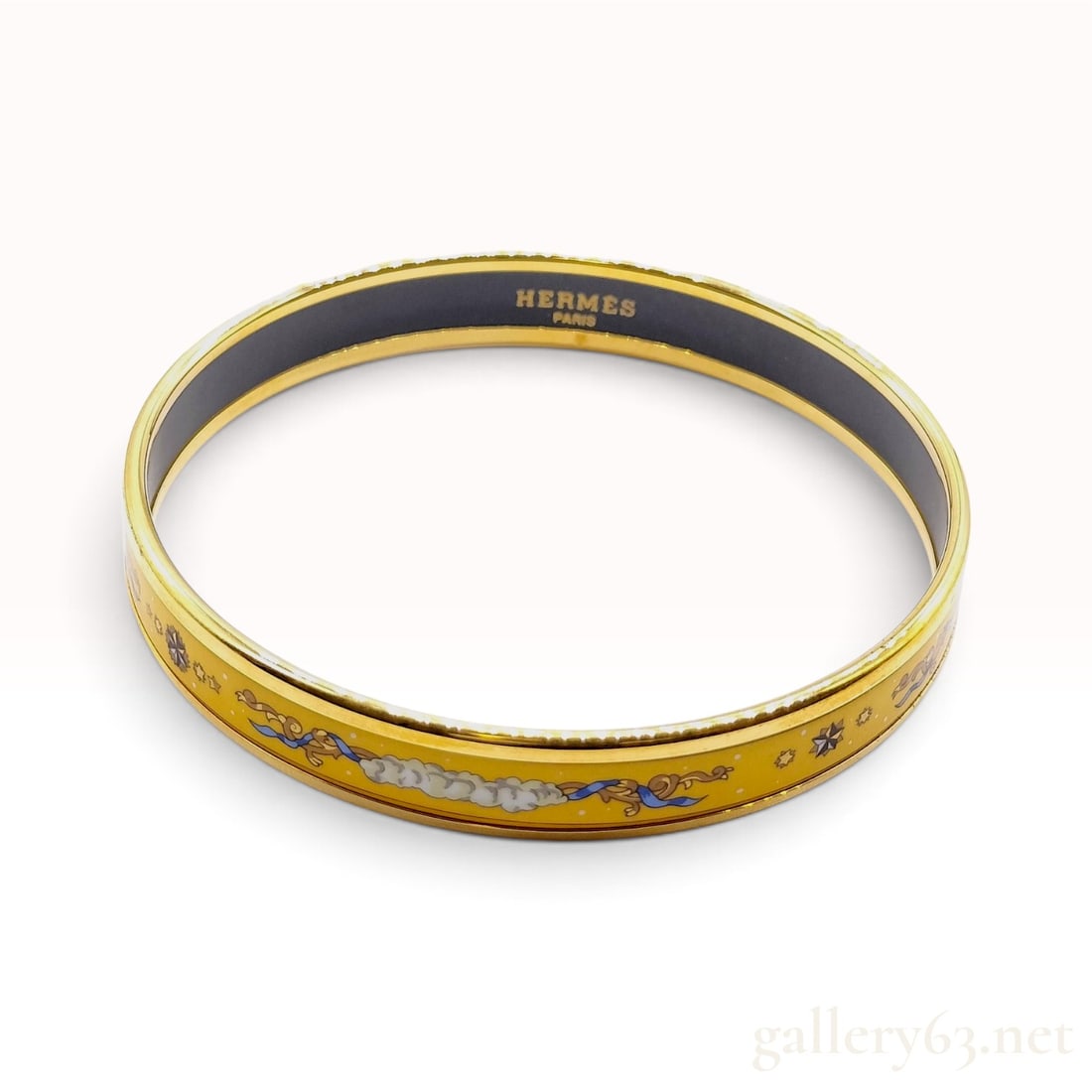 Vintage Hermes Ciels Byzantins Yellow Enamel Bangle: This Hermes bangle is constructed with a vibrant yellow enamel inlay bordered by polished gold-toned metal rims. The exterior enamel features the celestial Ciels Byzantins pattern, characterized by st