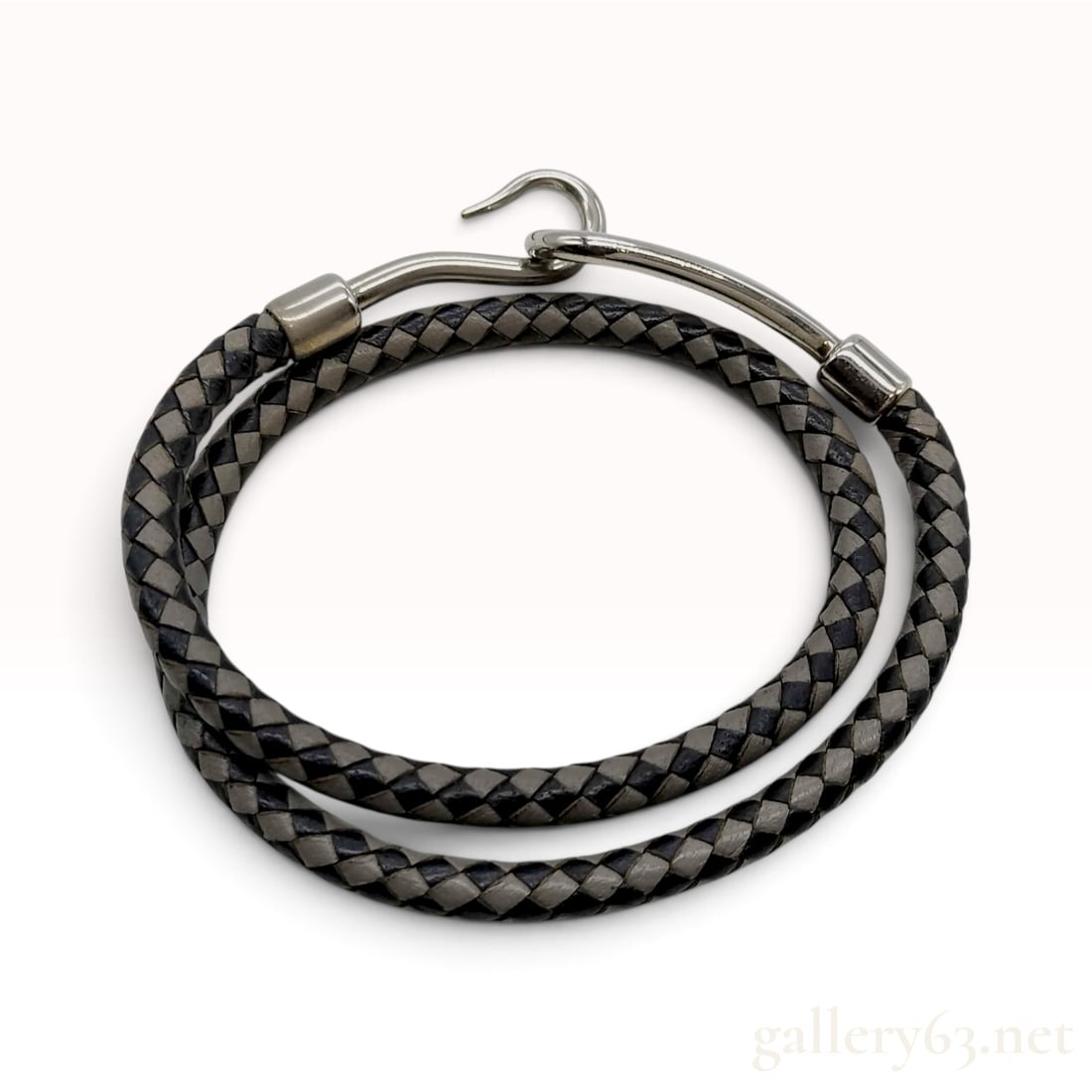 Hermes Black and Grey Braided Leather Double Wrap Bracelet: This Hermes bracelet is constructed from four-strand round-braided leather cord in a two-tone black and taupe-grey colorway. The double-wrap design terminates in metal hardware featuring a hook-and-ey