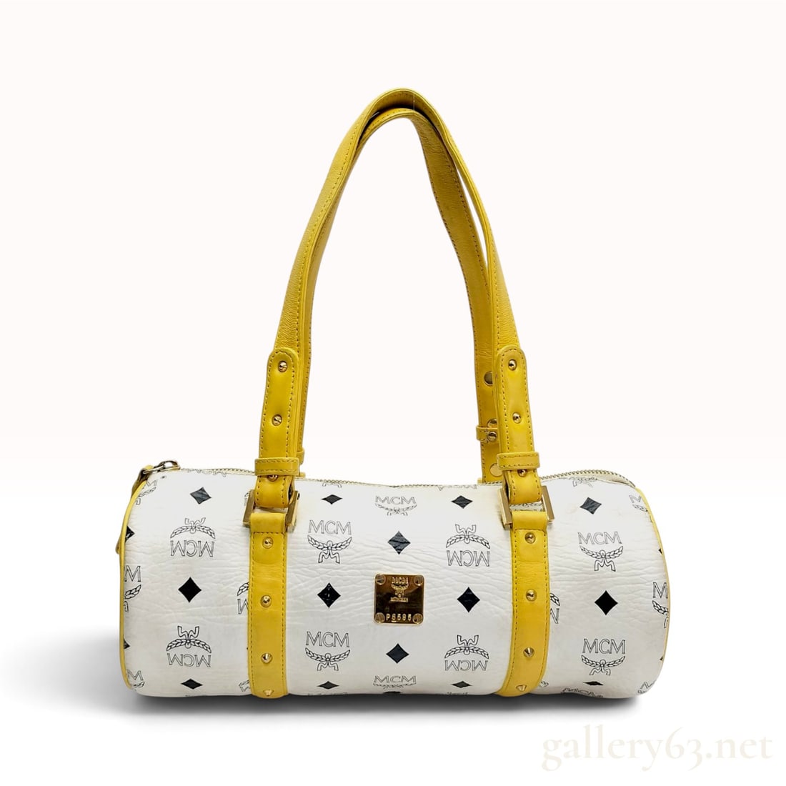MCM Visetos White and Yellow Coated Canvas Mini Boston Bag: This MCM mini Boston bag is crafted from white Visetos coated canvas featuring the signature black monogram, laurel wreath, and diamond motif. The barrel-shaped body is trimmed with yellow leather, in