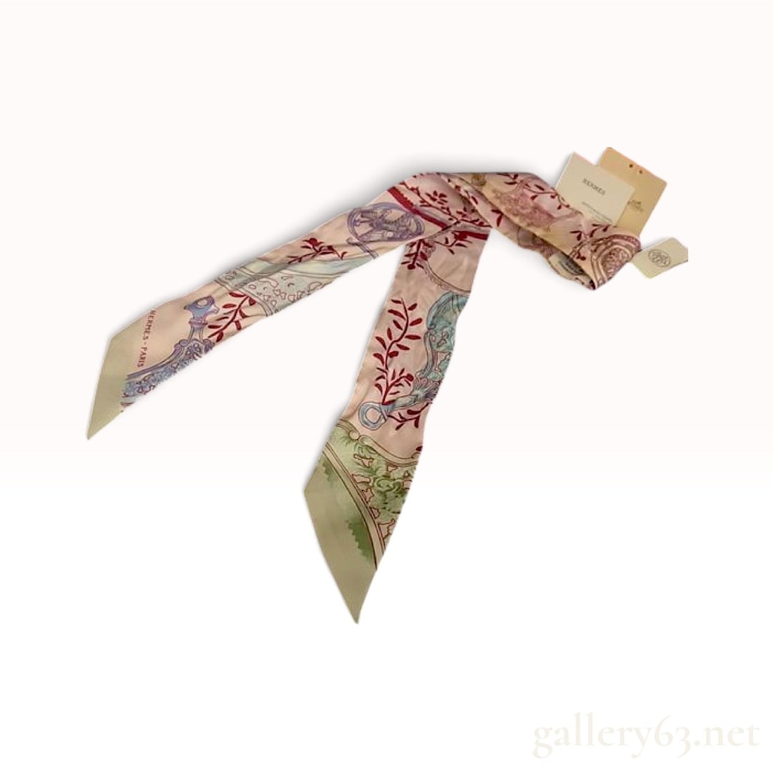 NWT Hermes Pink Silk Twilly with Tags: This French Hermes silk twilly is crafted from pink silk twill and features an ornate print of stylized stirrups, walking stick handles, scrolling foliage, and geometric borders in a color palette of 