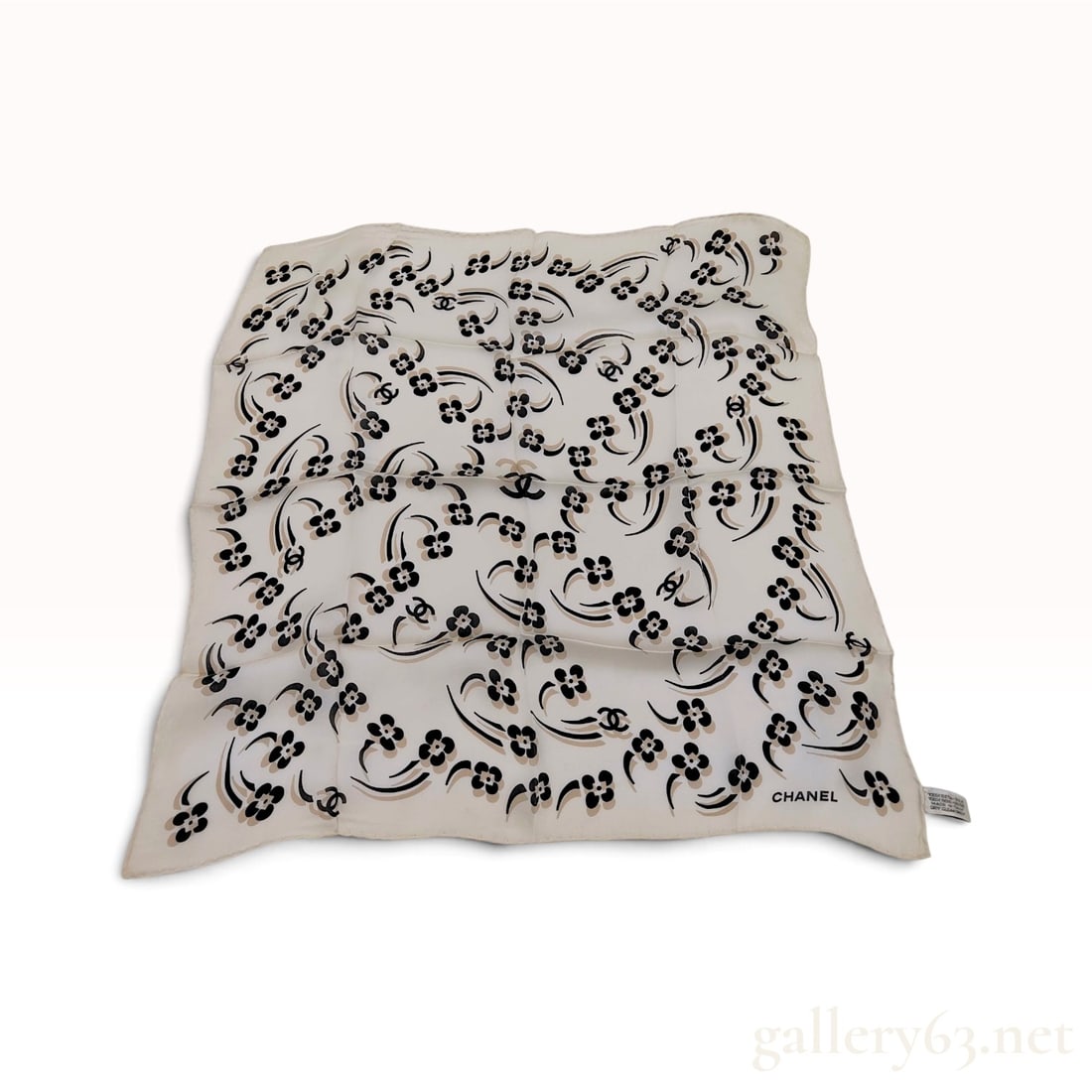 Vintage Chanel Camellia and CC Logo Cream Silk Scarf 60 cm: This Chanel square scarf is crafted from cream silk. The design features a scattered pattern of camellia blossoms in black and tan, interspersed with signature interlocking CC logos and flowing black 