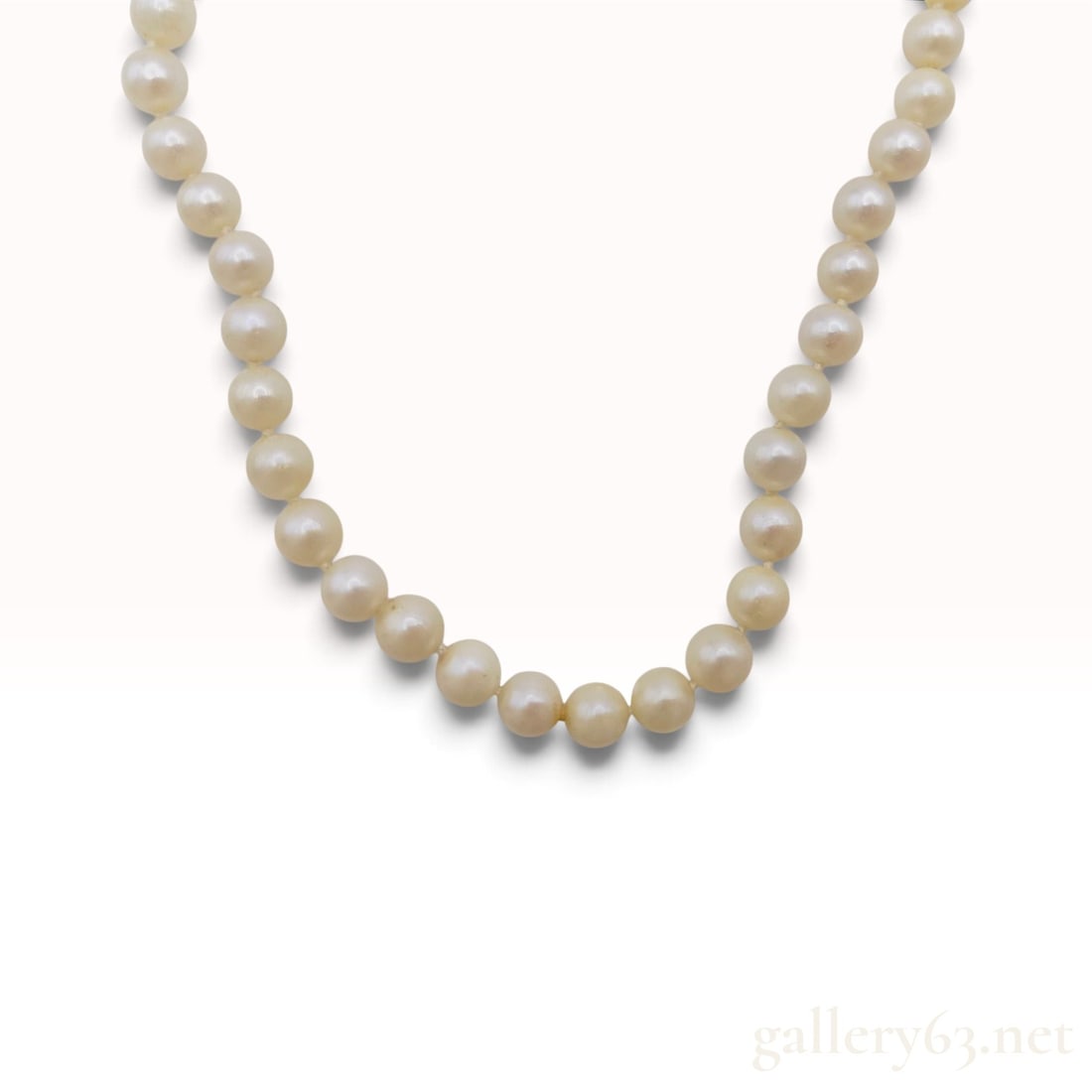 A Vintage 14 Karat Yellow Gold and Cultured Pearl Necklace: This vintage single-strand necklace is composed of approximately 64 individually knotted cultured pearls. The pearls exhibit a creamy-white body color with a soft luster and natural surface variations