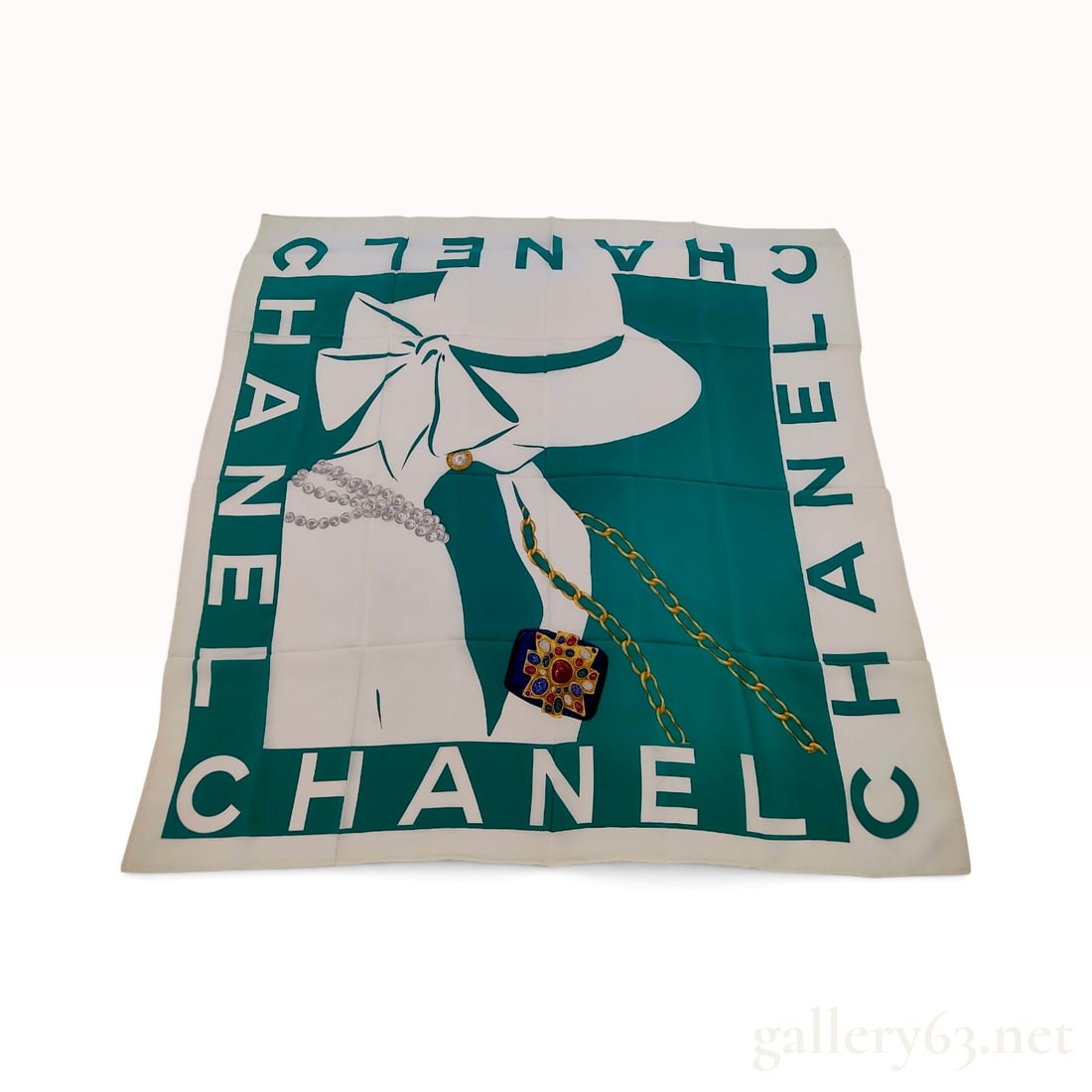 Vintage Chanel Mademoiselle Profile Green and White Silk Carre 90: This Chanel silk carre 90 features a graphic, stylized profile of Mademoiselle Coco Chanel wearing a wide-brimmed white hat with a large bow. The central illustration includes a multi-strand pearl nec