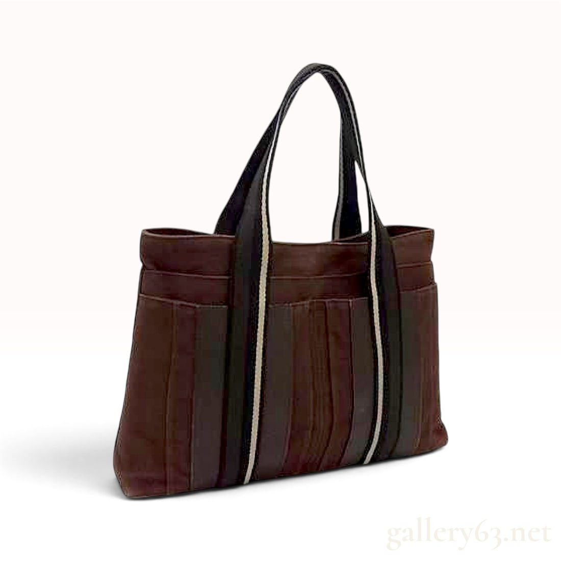Hermes Troca MM Dark Brown Toile and Leather Tote Bag: A Hermes Troca MM tote bag crafted from dark brown cotton canvas with tonal leather trim. The rectangular body features four slip pockets on each exterior face for organization. Two dark brown webbing