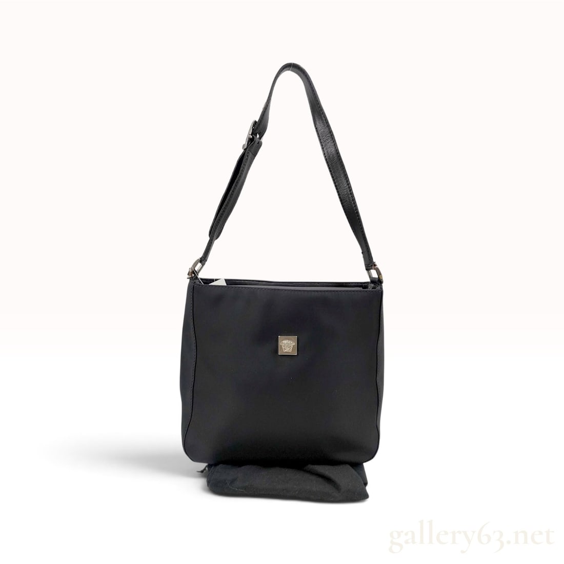 Versace Medusa Plaque Black Nylon Shoulder Bag with Dust Bag: This Versace shoulder bag is crafted from black nylon with leather trim and an adjustable leather shoulder strap. The front is centered with a square metal plaque featuring a raised Medusa head logo. 
