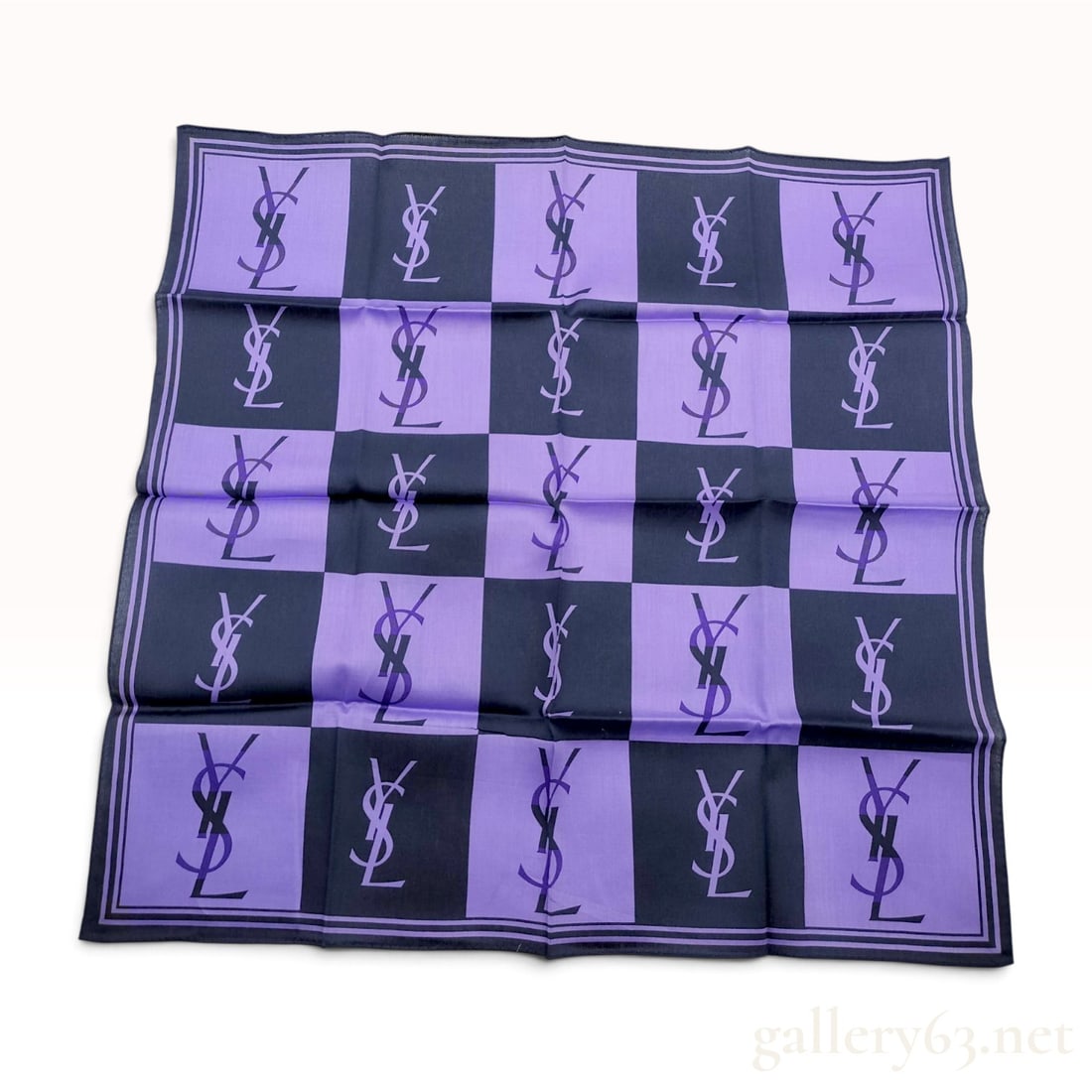 Vintage Yves Saint Laurent Monogram Checkerboard Purple and Navy Scarf 56 cm: This Yves Saint Laurent scarf is crafted from a purple and dark navy cotton-silk blend material. The design features a repeating checkerboard pattern where each square displays a contrasting version o