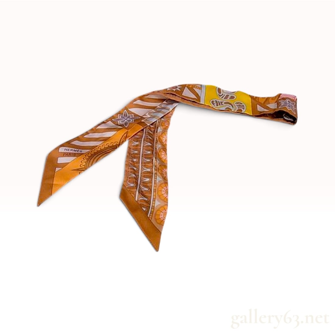Hermes Orange and Yellow Silk Twilly: This Hermes Twilly scarf is crafted from 100% silk featuring a multi-colored geometric and ornamental design. The pattern incorporates stylized floral medallions, stripes, and scrollwork in a palette 