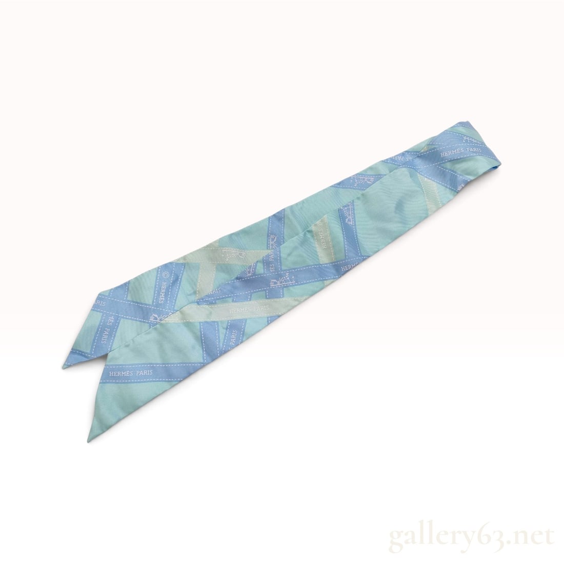 Herm?¨s Bolduc Light Blue and Mint Green Silk Twilly Scarf with Box: This Herm?¨s Twilly scarf is crafted from 100% silk and features the classic Bolduc ribbon motif. The design consists of overlapping ribbons in shades of light blue and mint green, patterned with the