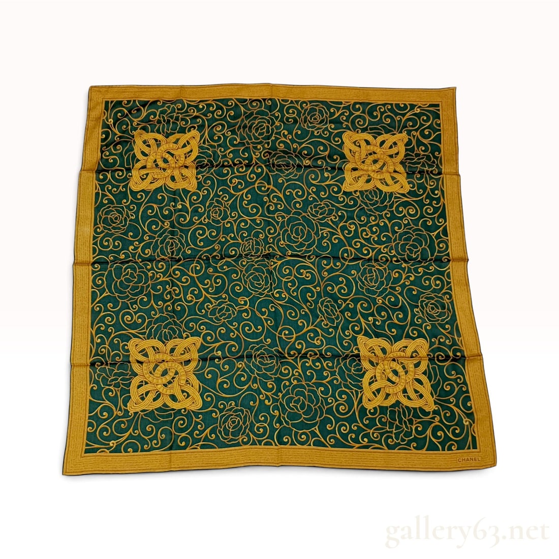 Chanel Filigree and Camellia Green and Gold Silk Scarf 85 cm: This Chanel silk scarf is crafted from 100% silk in Italy. The dark forest green field is decorated with a golden yellow all-over scrolling filigree and camellia floral motif. Four large medallions fe