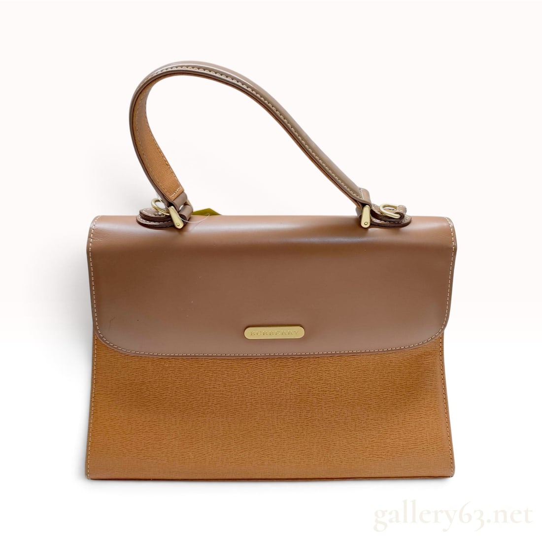 Vintage Burberry Two-Tone Brown and Tan Leather Top-Handle Satchel Bag: A vintage Burberry top-handle satchel bag crafted from a combination of smooth and textured leathers. The structured silhouette features a smooth brown leather top flap and a single rolled handle. The