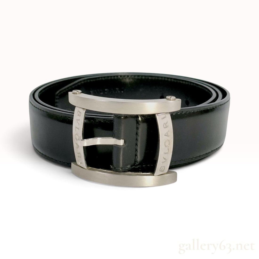 Bvlgari Black Leather Belt 95 cm: This Bvlgari belt is crafted from black leather featuring a rectangular arched frame buckle with mixed brushed and polished metal finishes. The strap is constructed with tonal topstitching along the e