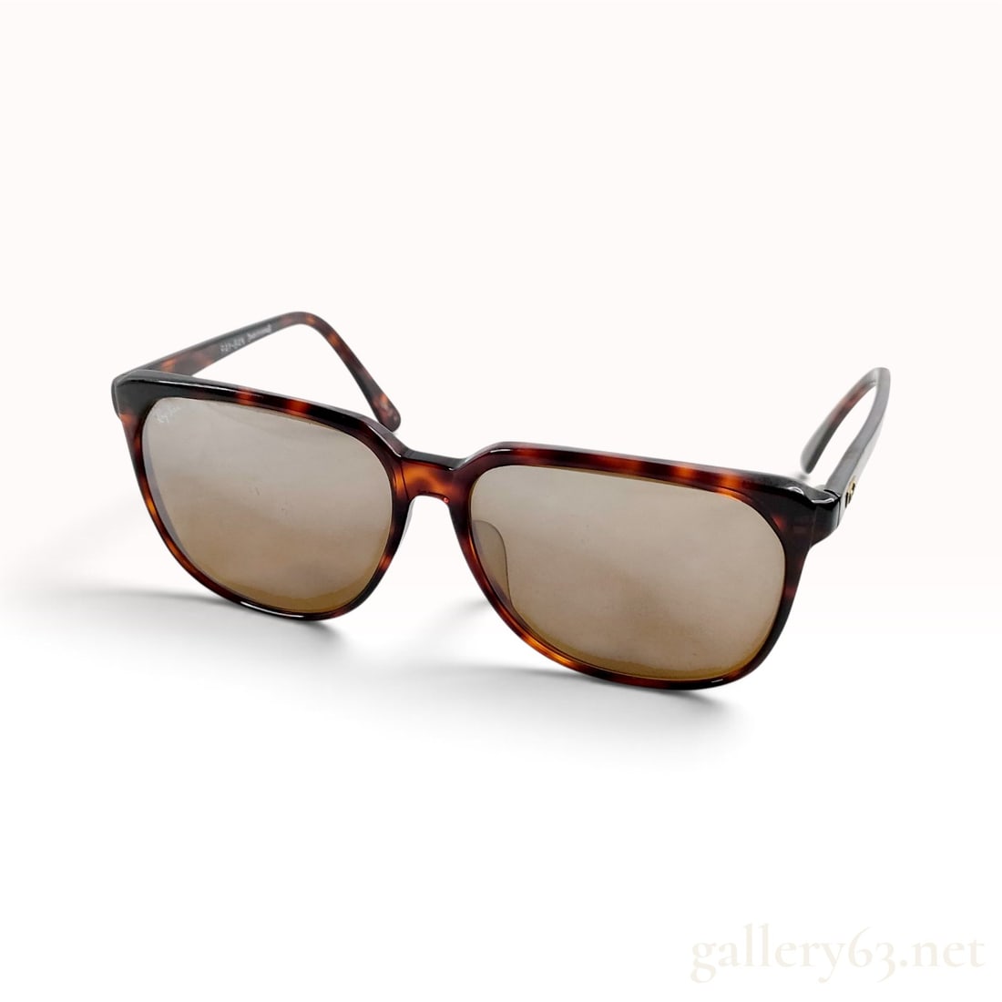 Vintage Ray-Ban Traditionals Brooklyn #104 Tortoiseshell Acetate Sunglasses: This Ray-Ban Traditionals Brooklyn #104 sunglasses model is crafted from dark tortoiseshell acetate with a squared-off frame design and amber-tinted lenses. The upper corner of the left lens is marked