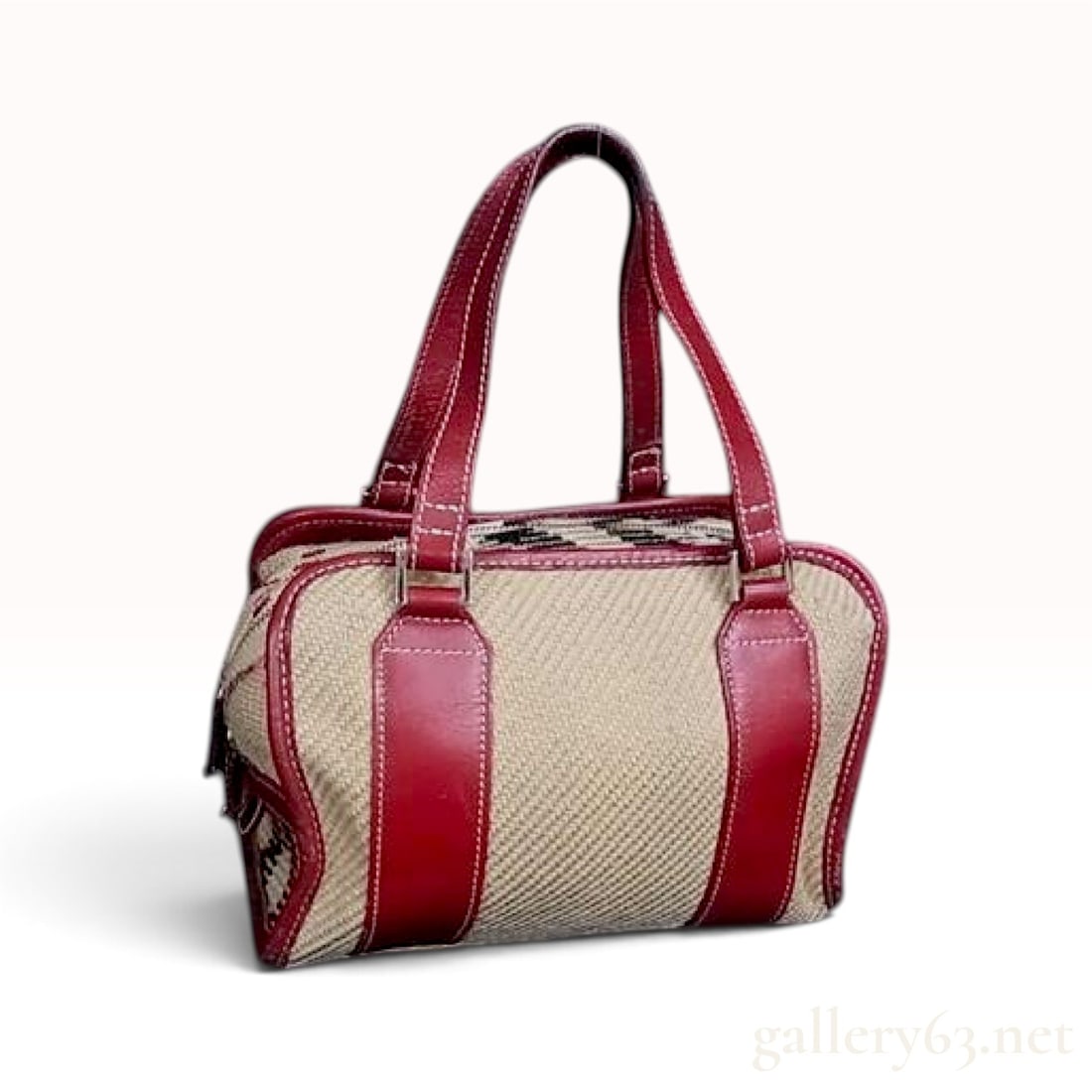 Burberry Blue Label Beige Woven Canvas and Red Leather Satchel: This Burberry Blue Label satchel is crafted with a beige woven canvas body featuring a herringbone texture. The exterior is trimmed with red leather, including two vertical straps on each face and pip